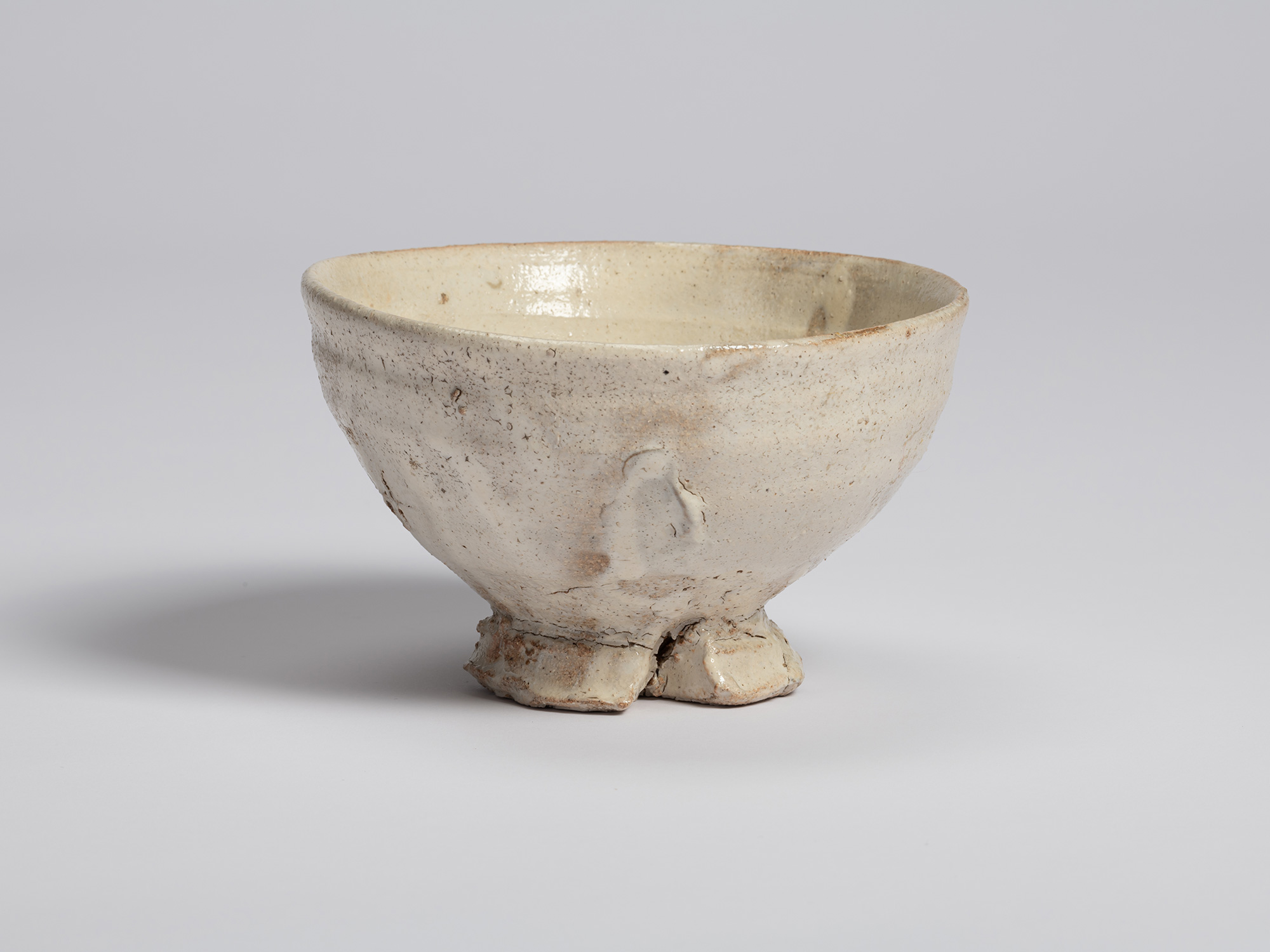 View of Shiro Tsujimura’s tea bowl showing a raised fold in the clay along one side of the vessel....