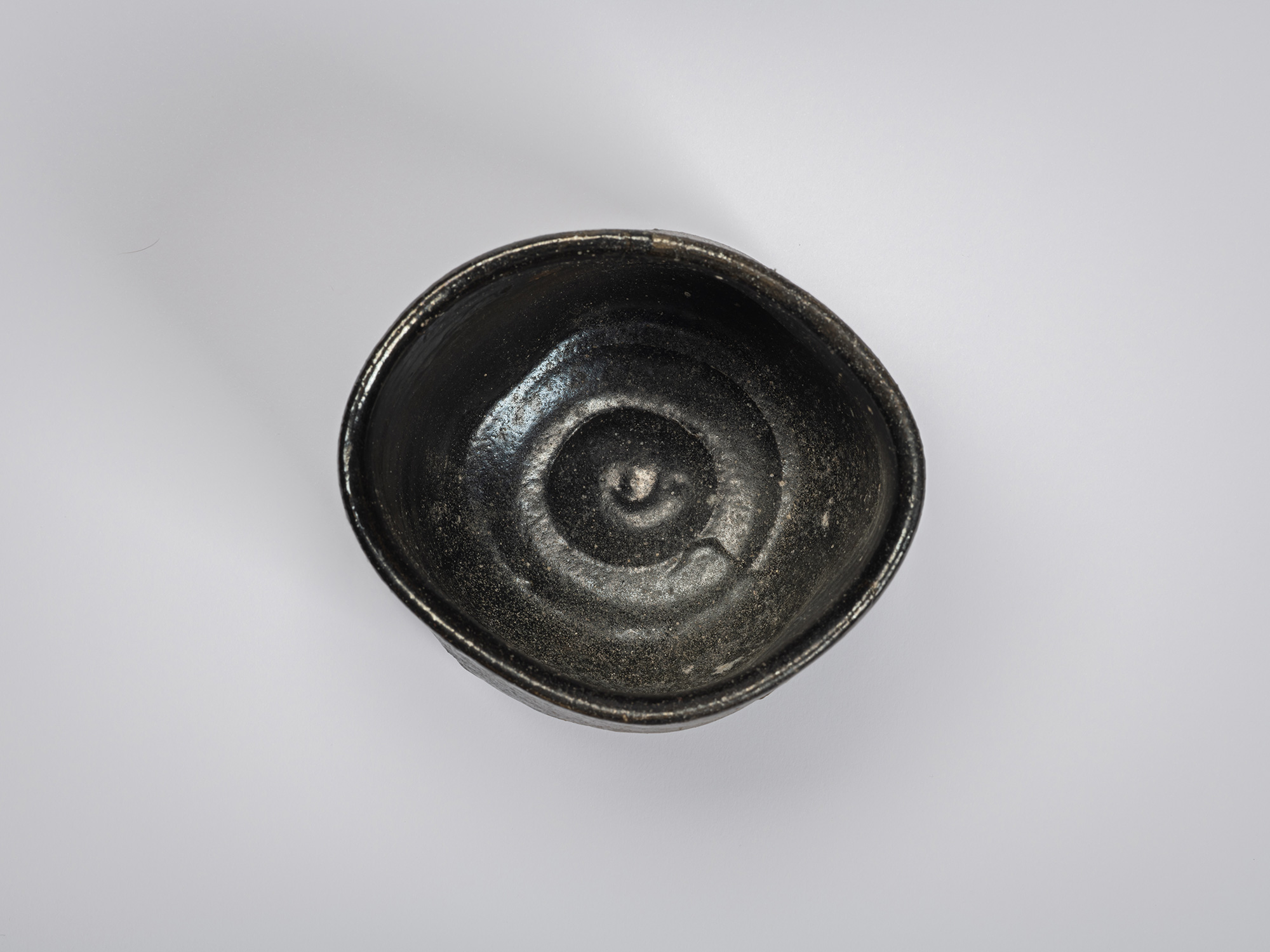 Overhead view of a Hikidashi-style tea bowl by Shiro Tsujimura showing the interior. The glossy...