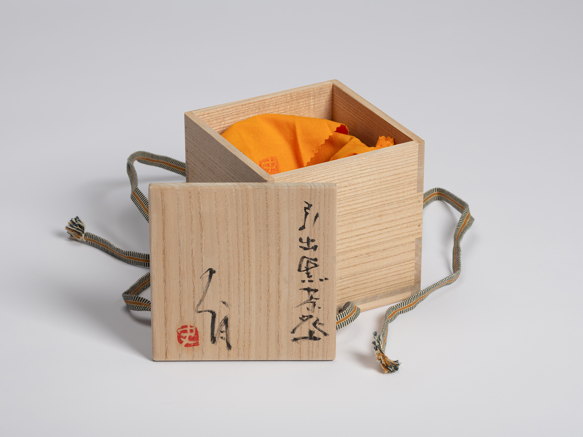 Tomobako for a Hikidashi-style tea bowl by Shiro Tsujimura. The paulownia wood storage box is shown...