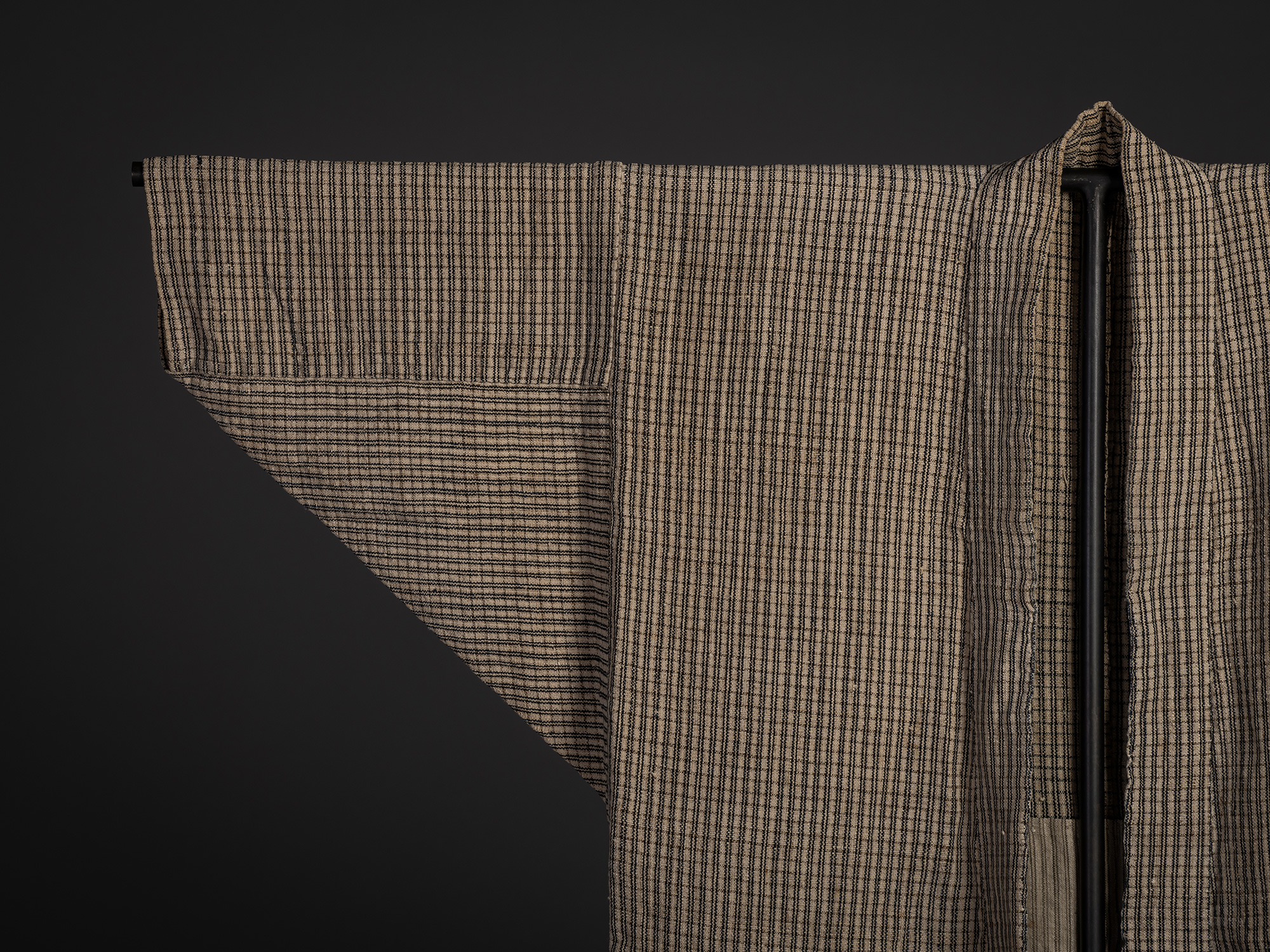 Close-up of the right shoulder and sleeve of the Tsushima jacket, showing its finely woven black-and-natural...