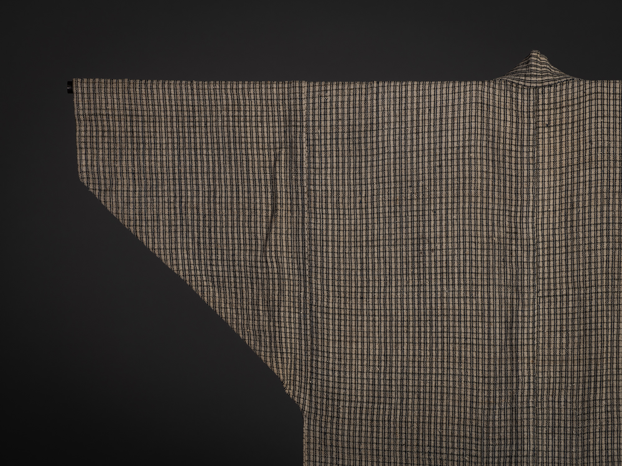 Close-up of the upper back and right sleeve of the Tsushima jacket. The small-scale check pattern...