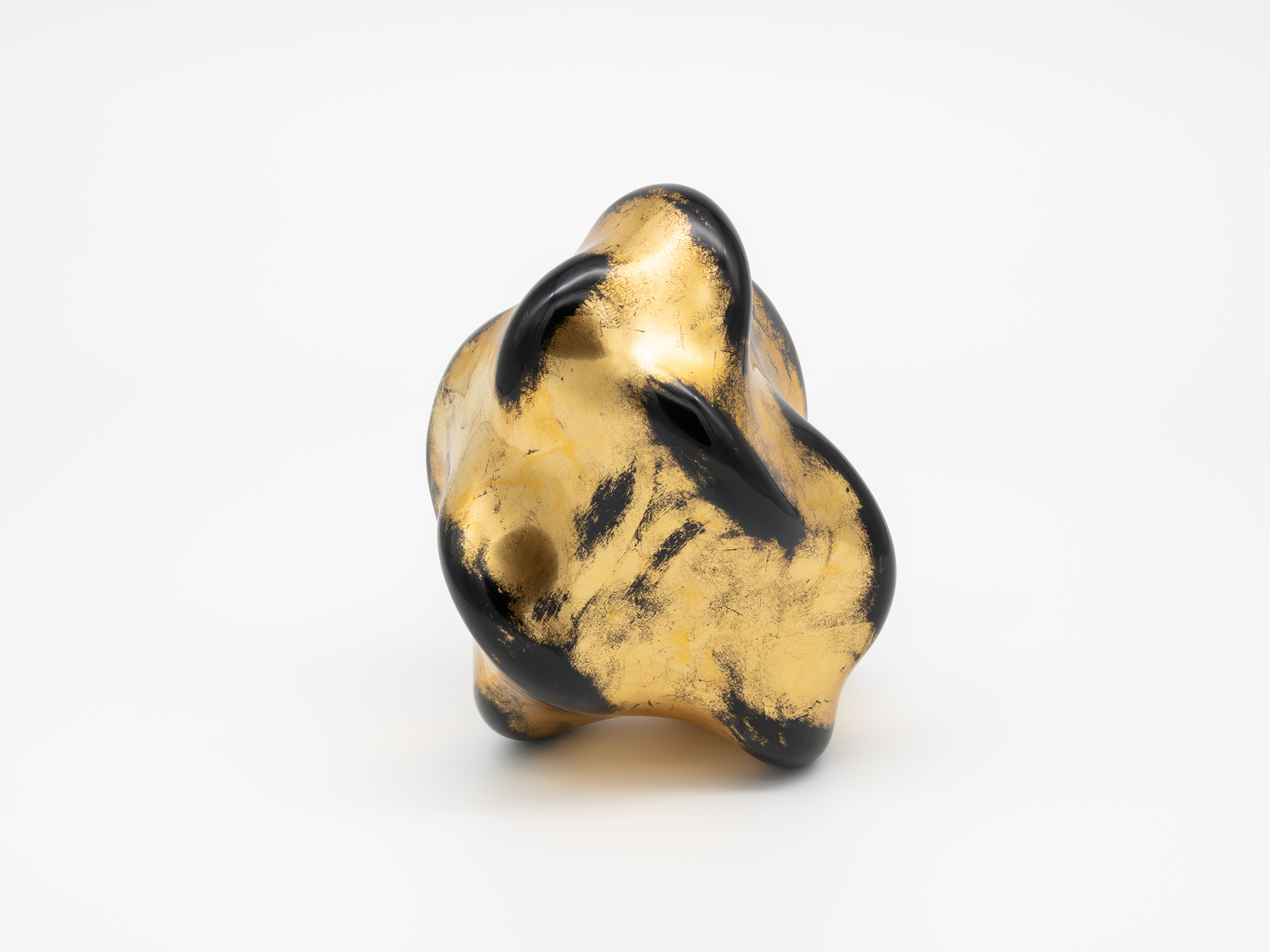 Side view of Untitled (Faded Gold) highlighting its asymmetrical silhouette and layered folds....