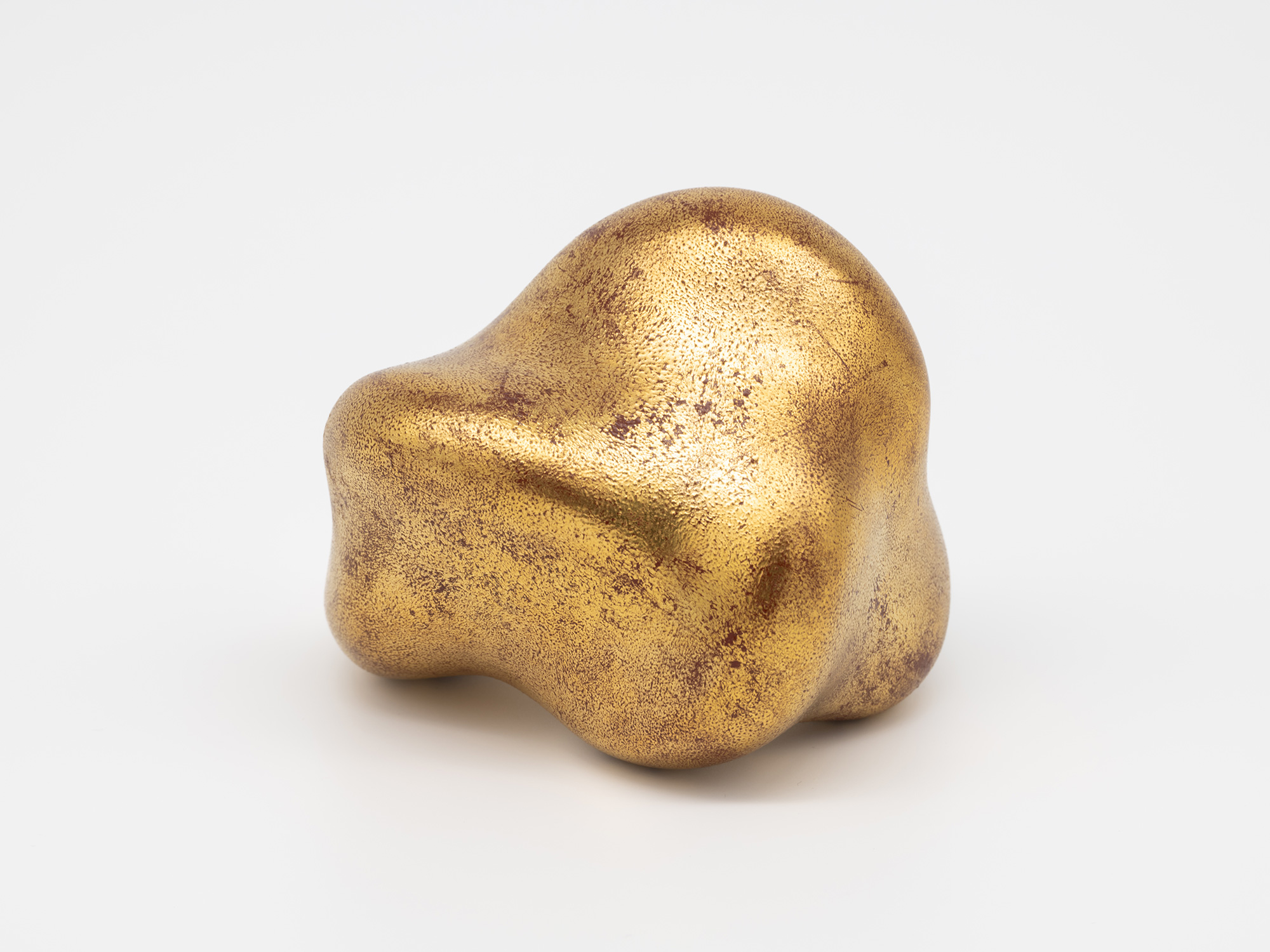 View of Untitled (Faded Gold) showing an irregular arrangement of rounded lobes and recessed areas....