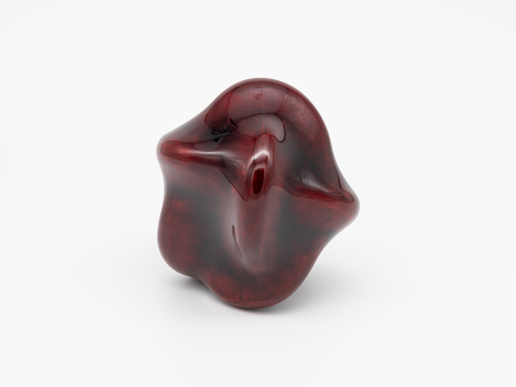 View of Untitled (Star) showing an irregular, biomorphic form with a glossy translucent red lacquer...