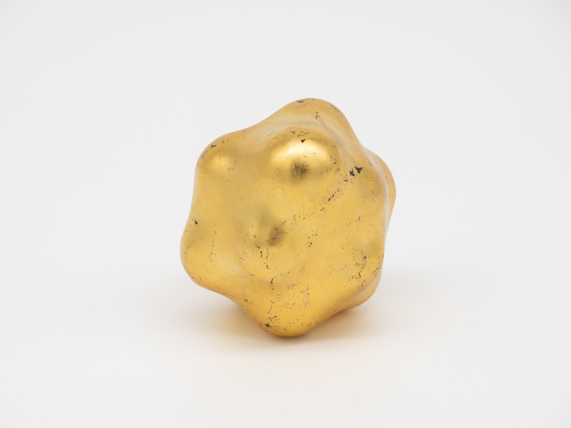 Close view of Untitled emphasizing its gold leaf finish and organic modeling. Rounded elevations,...