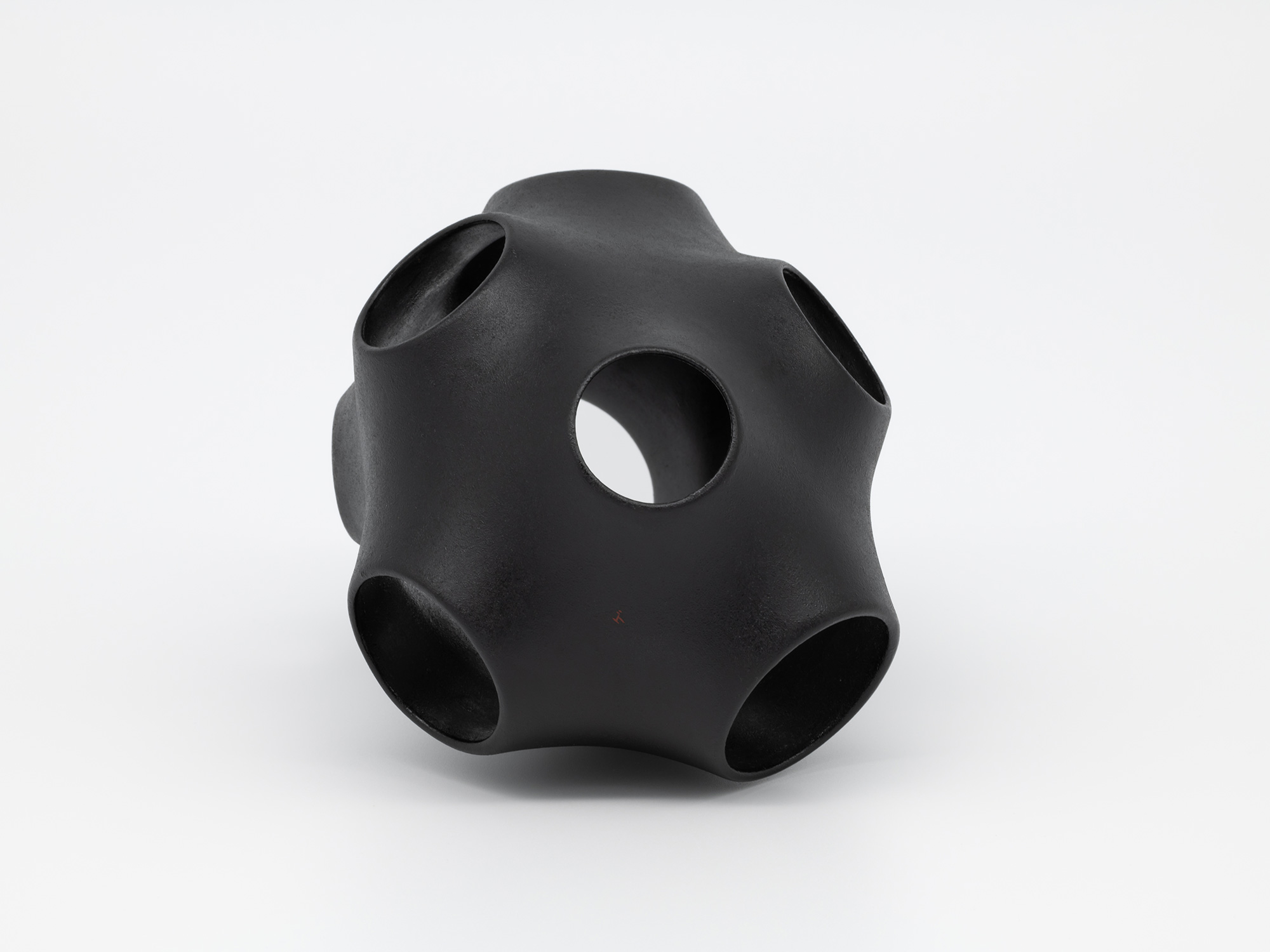 Bottom view of Absence – Holes by Genta Ishizuka, a matte black lacquer sculpture with rounded...