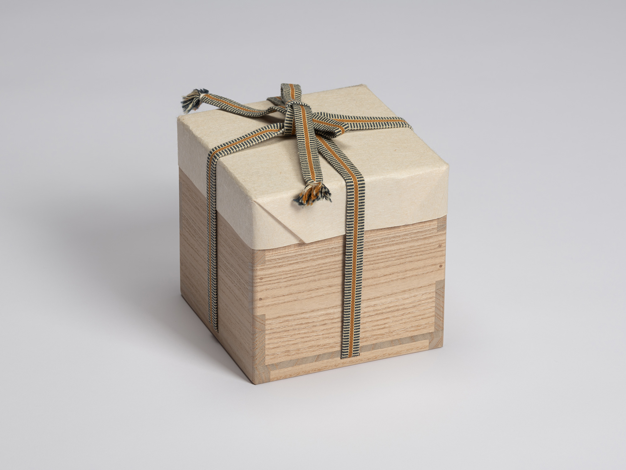 Outer paulownia wood storage box for Chawan No. 10, wrapped in protective paper and secured with...