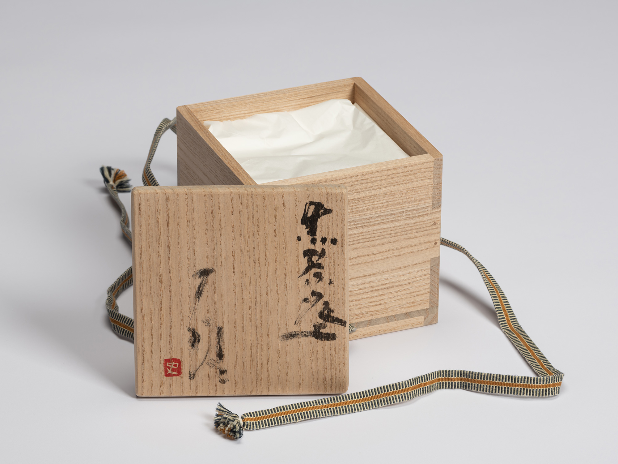 Signed wooden presentation box (tomobako) for Chawan No. 10 by Shiro Tsujimura, shown with the...