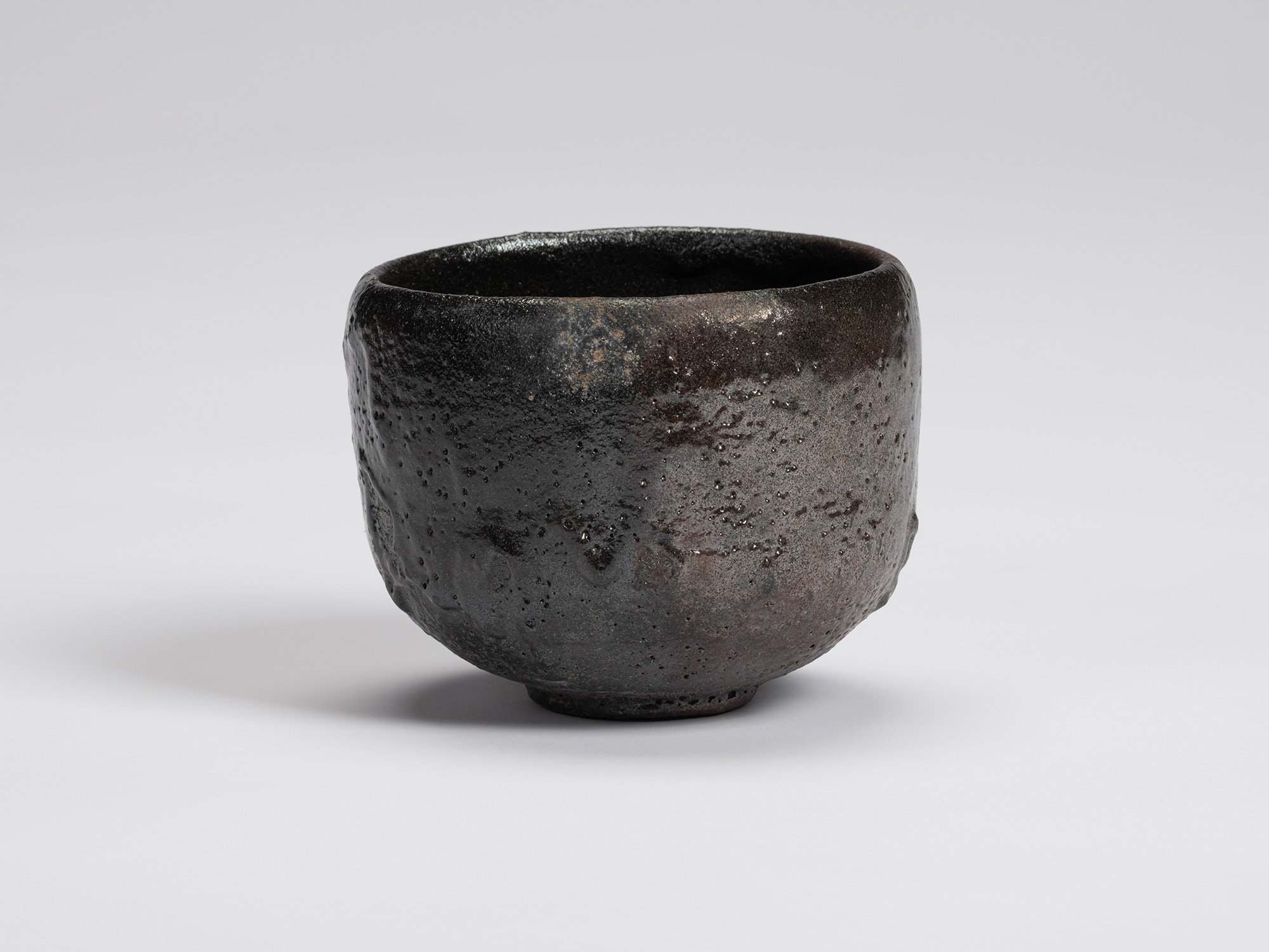 Front view of Chawan No. 13 by Shiro Tsujimura, a hand-formed black tea bowl with a rounded cylindrical...
