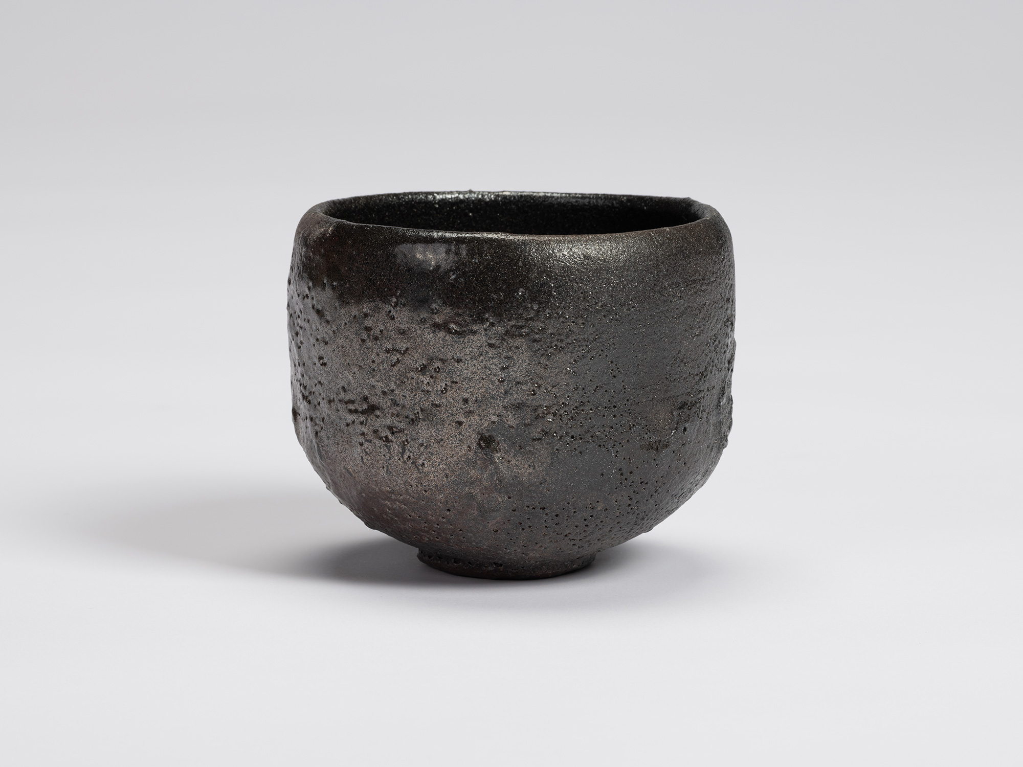 Front view of Chawan No. 13 by Shiro Tsujimura, a hand-formed black tea bowl with a rounded cylindrical...