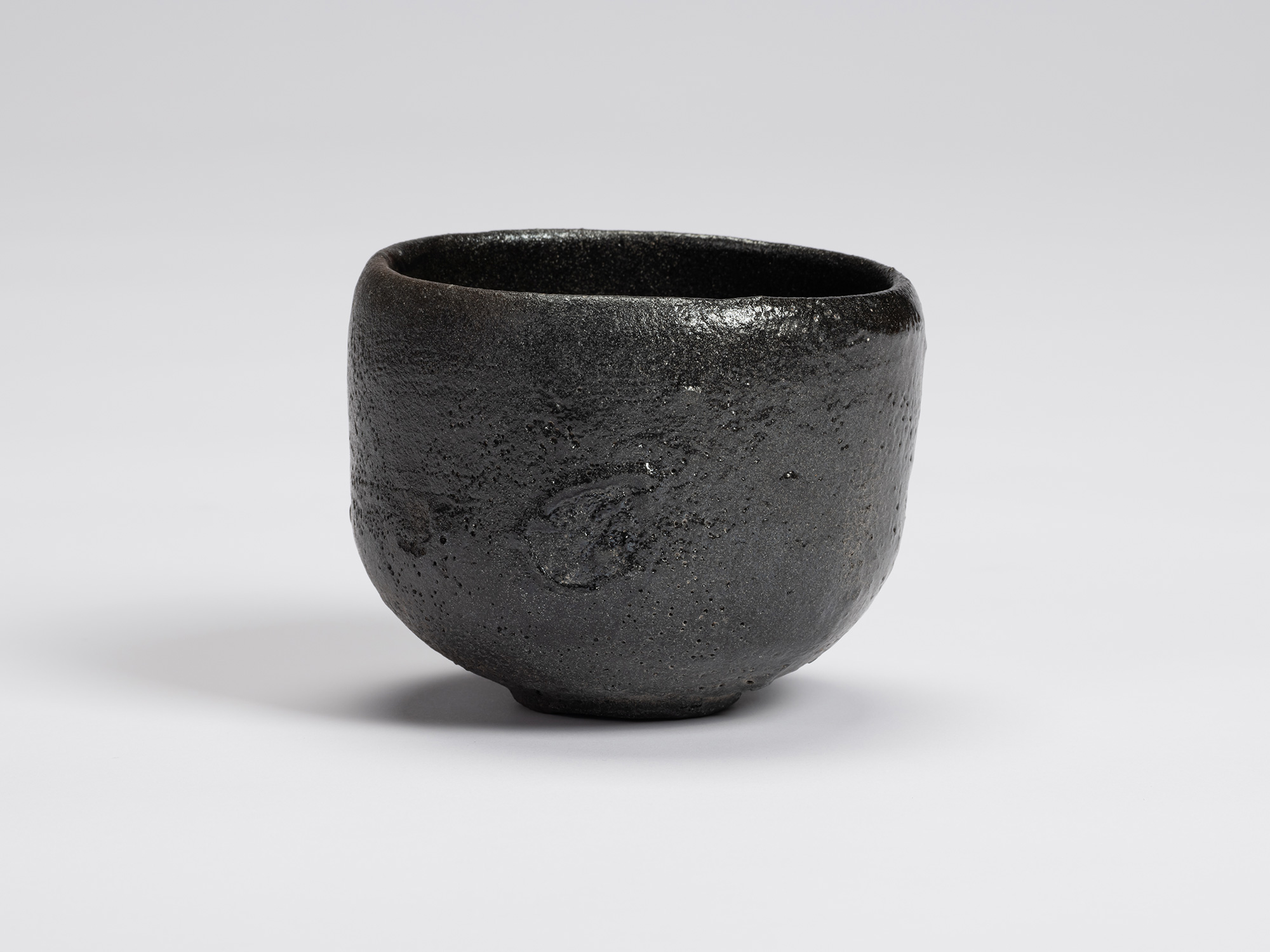 Front view of Chawan No. 13 by Shiro Tsujimura, a hand-formed black tea bowl with a rounded cylindrical...
