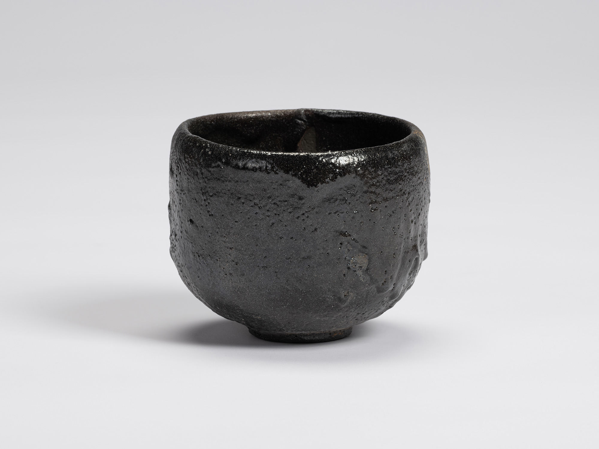 Front view of Chawan No. 13 by Shiro Tsujimura, a hand-formed black tea bowl with a rounded cylindrical...