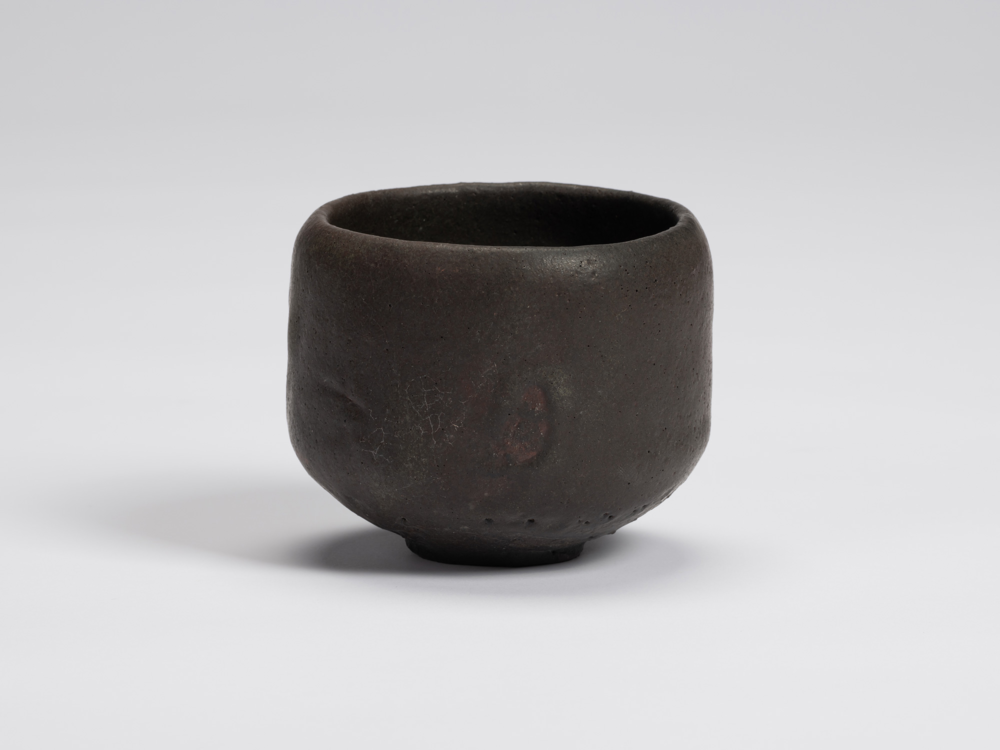 Front view of Chawan No. 14 by Shiro Tsujimura, a hand-formed black tea bowl with a gently rounded...