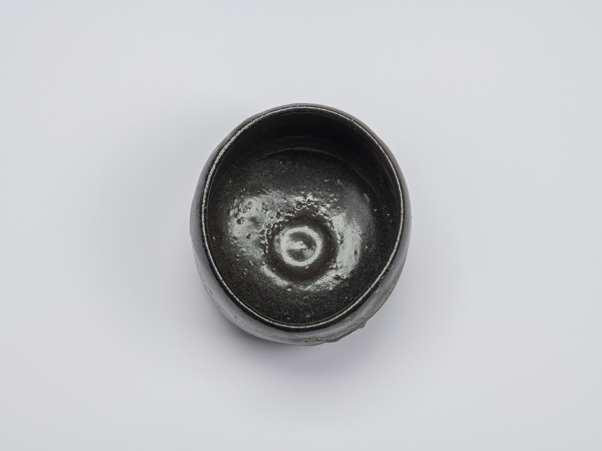 Overhead view of Chawan No. 15 showing its nearly circular mouth, glossy black interior, and rounded...