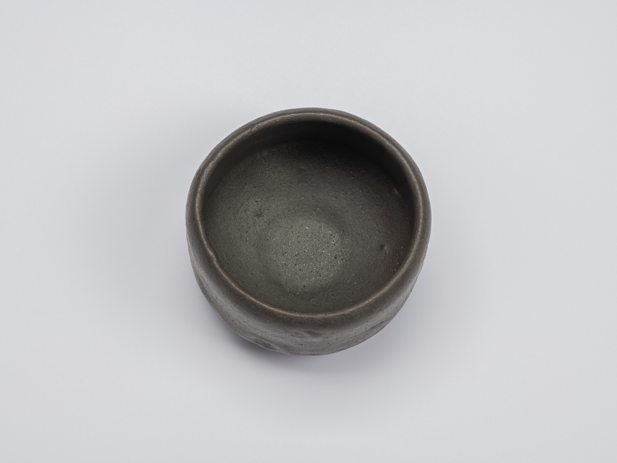 Overhead view of Chawan No. 16, revealing its circular opening, gently rounded rim, and quiet gray-black...