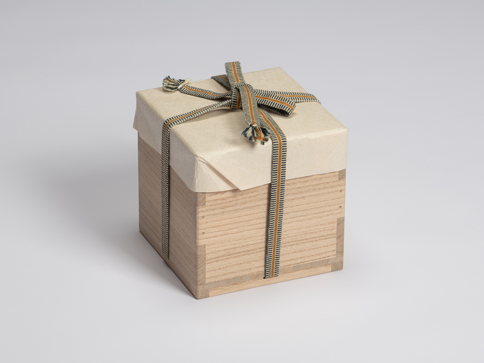 Closed paulownia wood tomobako for Shiro Tsujimura’s Kuro Chawan wrapped in protective paper and...