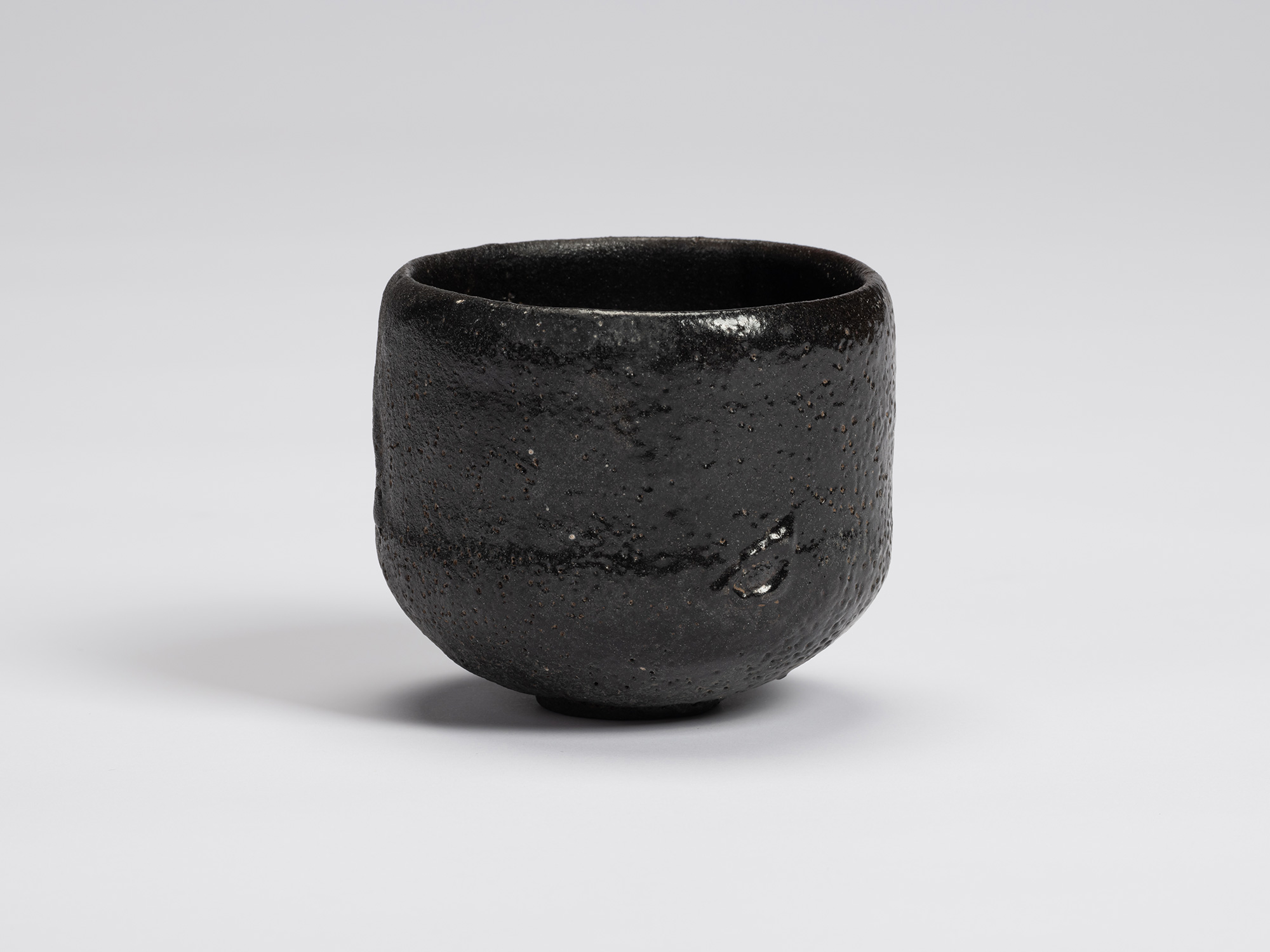 Front view of Chawan No. 17 by Shiro Tsujimura, a hand-formed black tea bowl with a gently cylindrical...