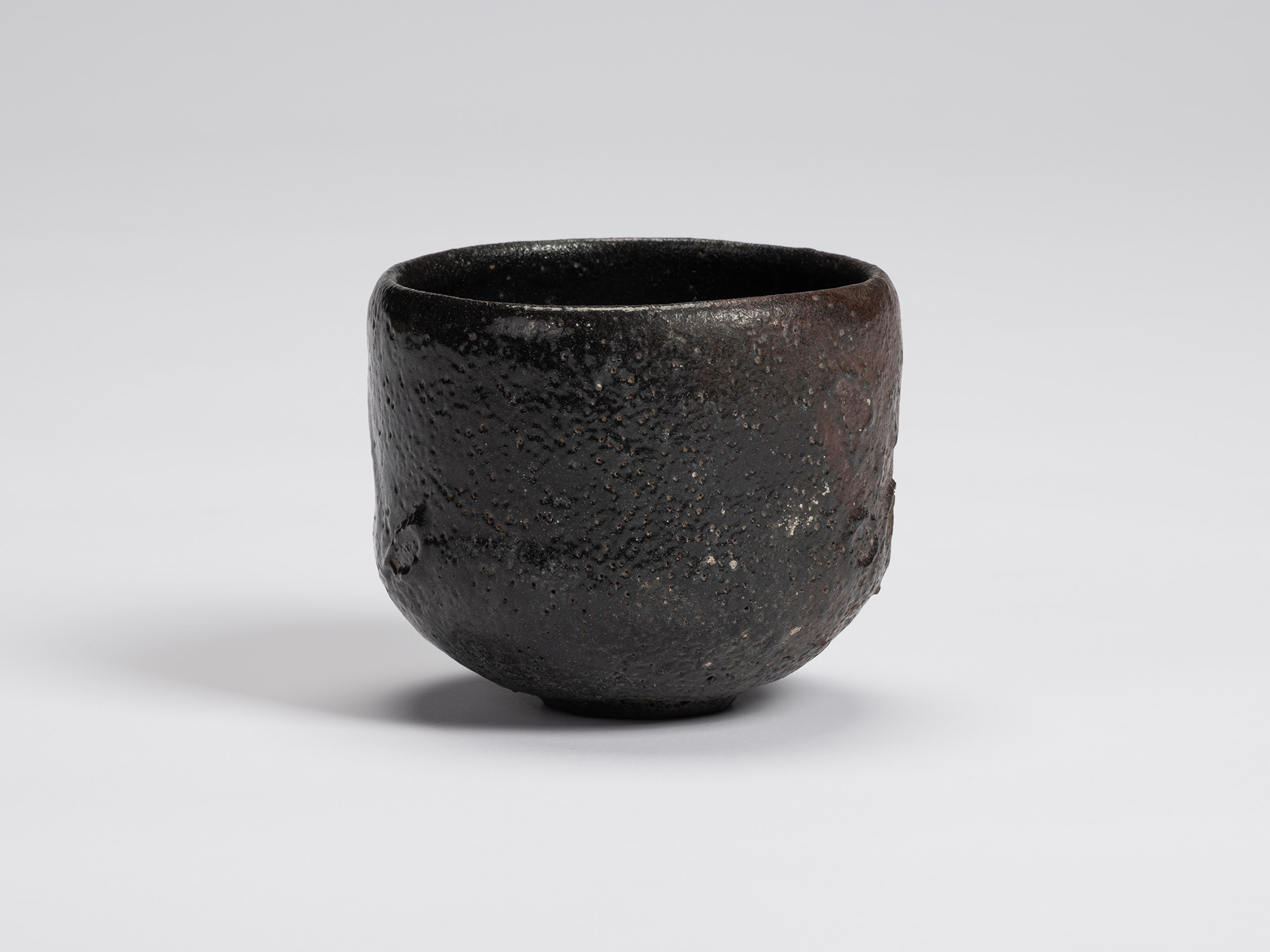Front view of Chawan No. 17 by Shiro Tsujimura, a hand-formed black tea bowl with a gently cylindrical...