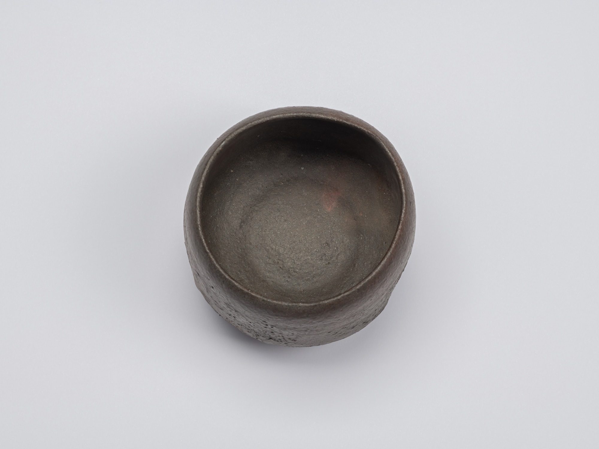 Overhead view of Kuro Chawan revealing a deep, rounded interior with a smooth, burnished surface...