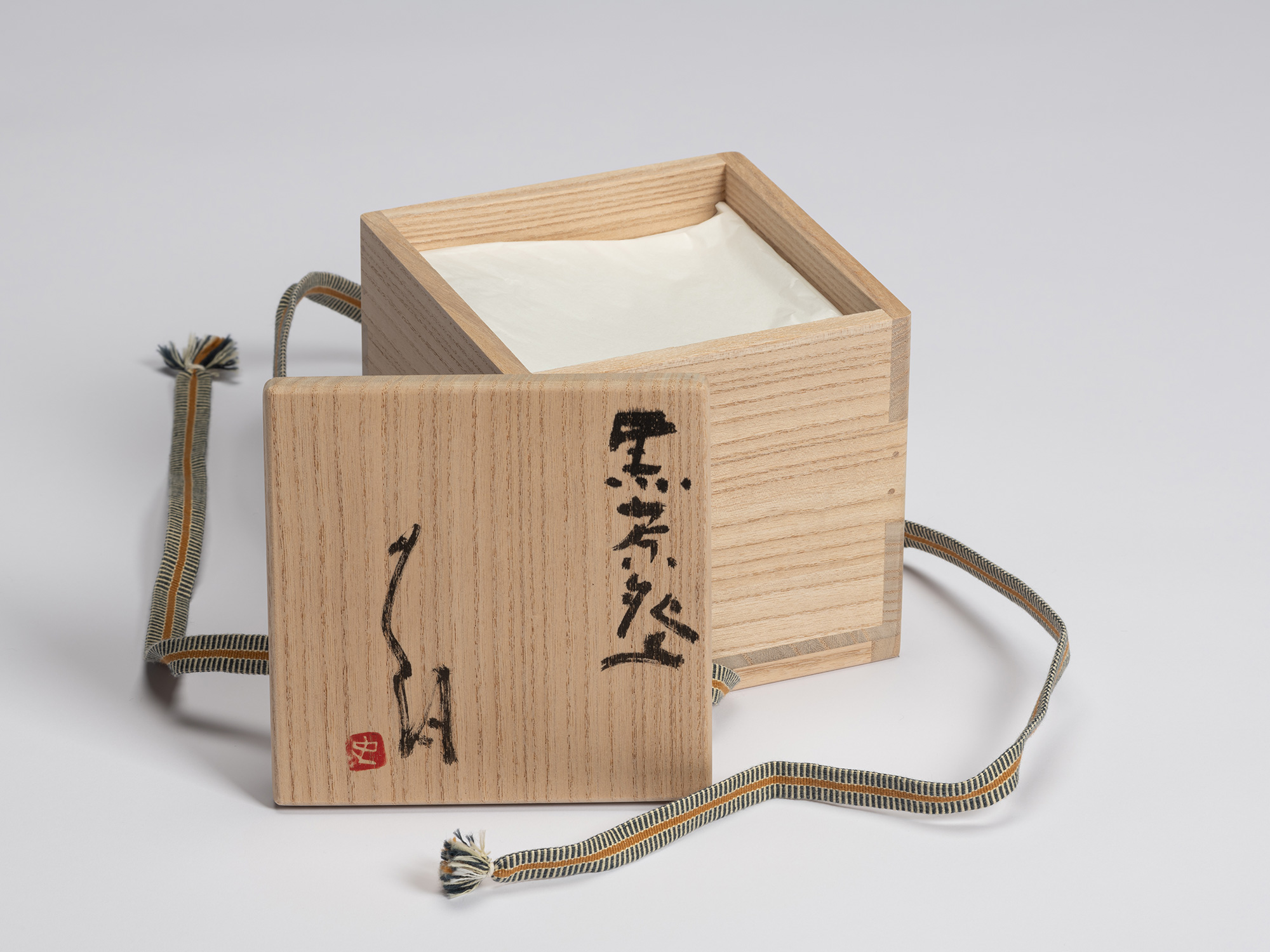 Open signed paulownia wood tomobako displaying the inscription 「黒茶碗」(Kuro Chawan / Black Tea Bowl)...