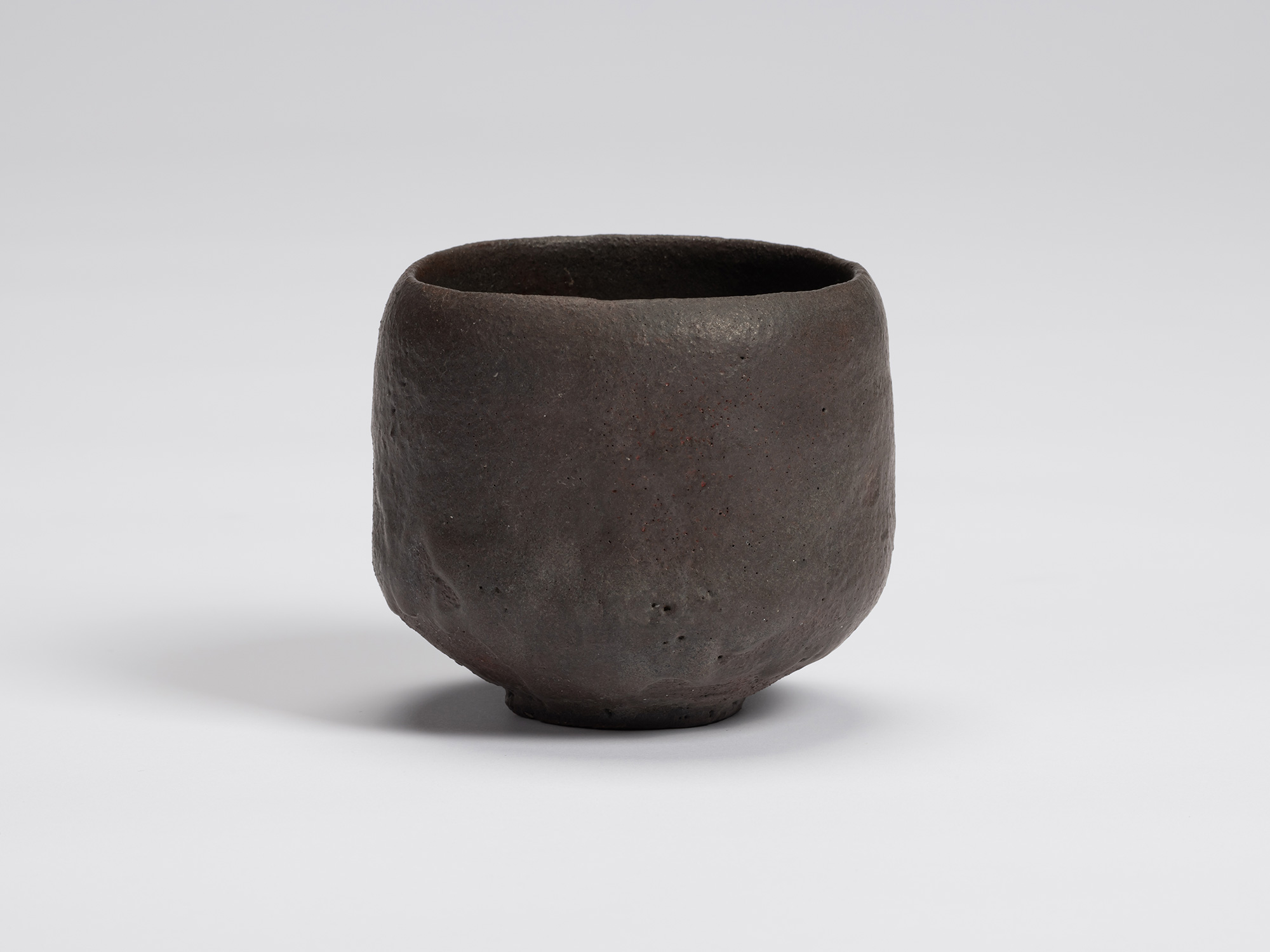 View of Kuro Chawan by Shiro Tsujimura, a hand-formed black tea bowl with gently rounded walls,...