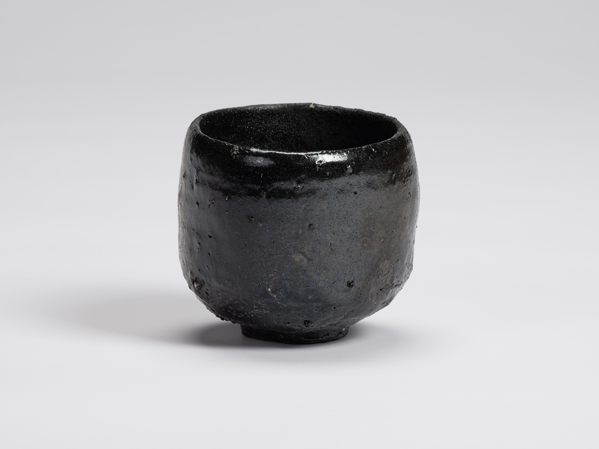 Front view of Kuro Chawan by Shiro Tsujimura, a hand-formed black tea bowl with softly rounded...