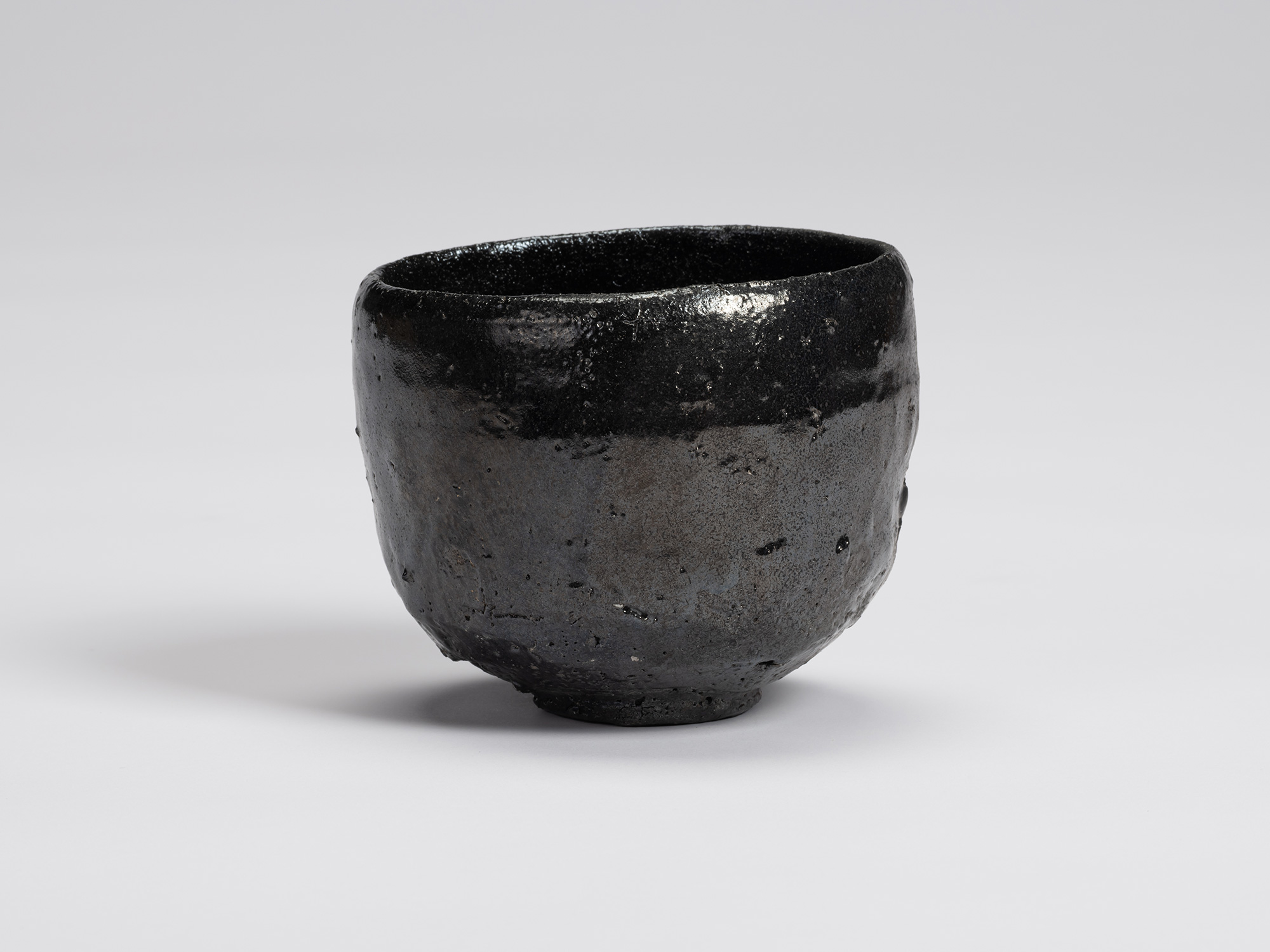Front view of Kuro Chawan by Shiro Tsujimura, a hand-formed black tea bowl with softly rounded...