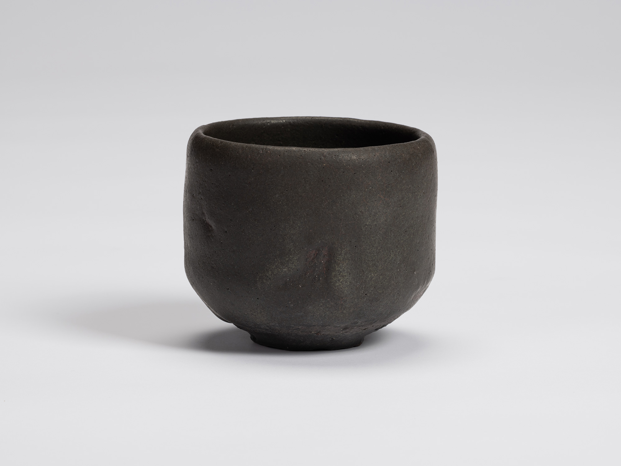 Front view of Kuro Chawan by Shiro Tsujimura, a hand-formed black tea bowl with gently rounded...