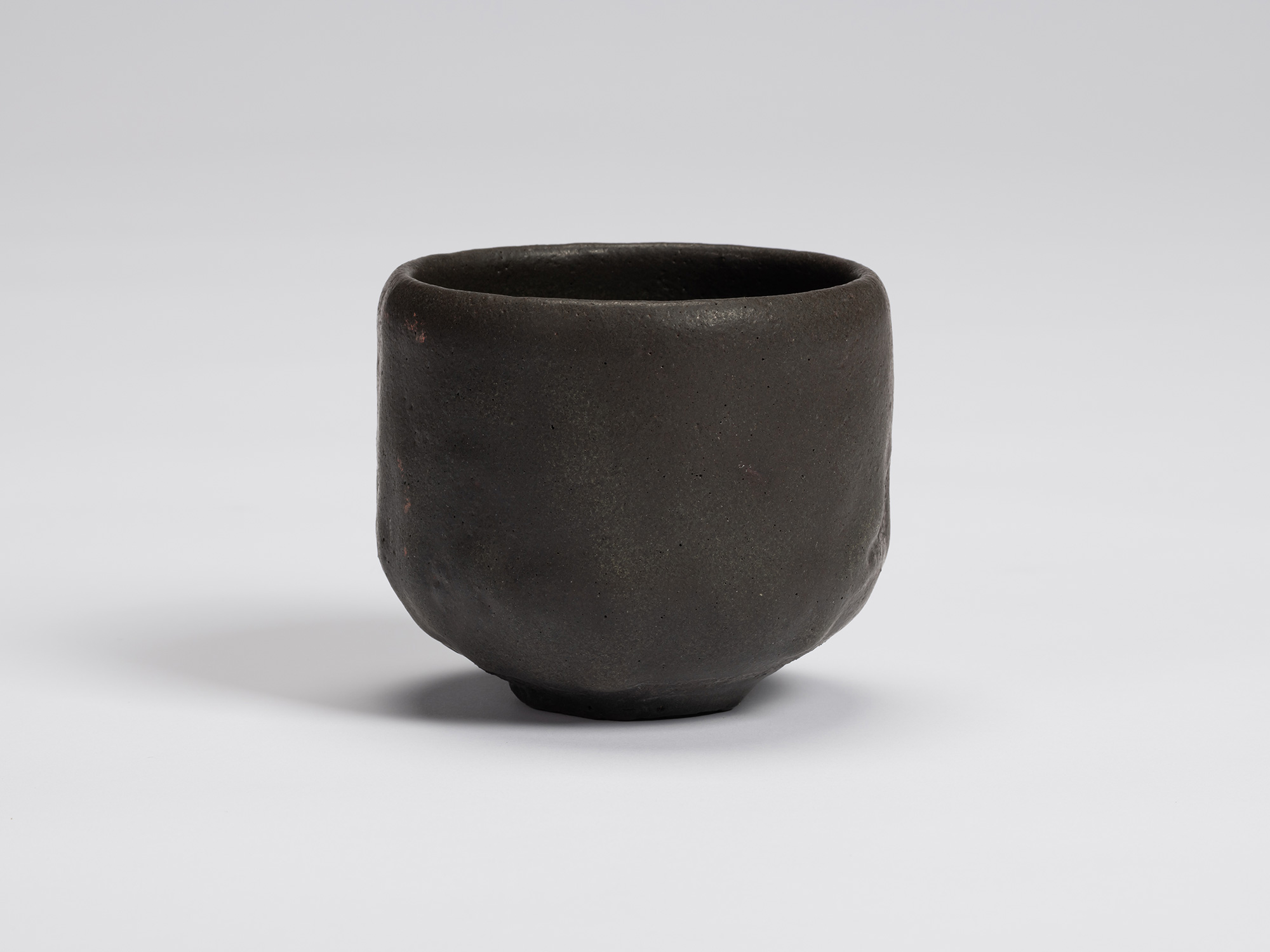 Front view of Kuro Chawan by Shiro Tsujimura, a hand-formed black tea bowl with gently rounded...