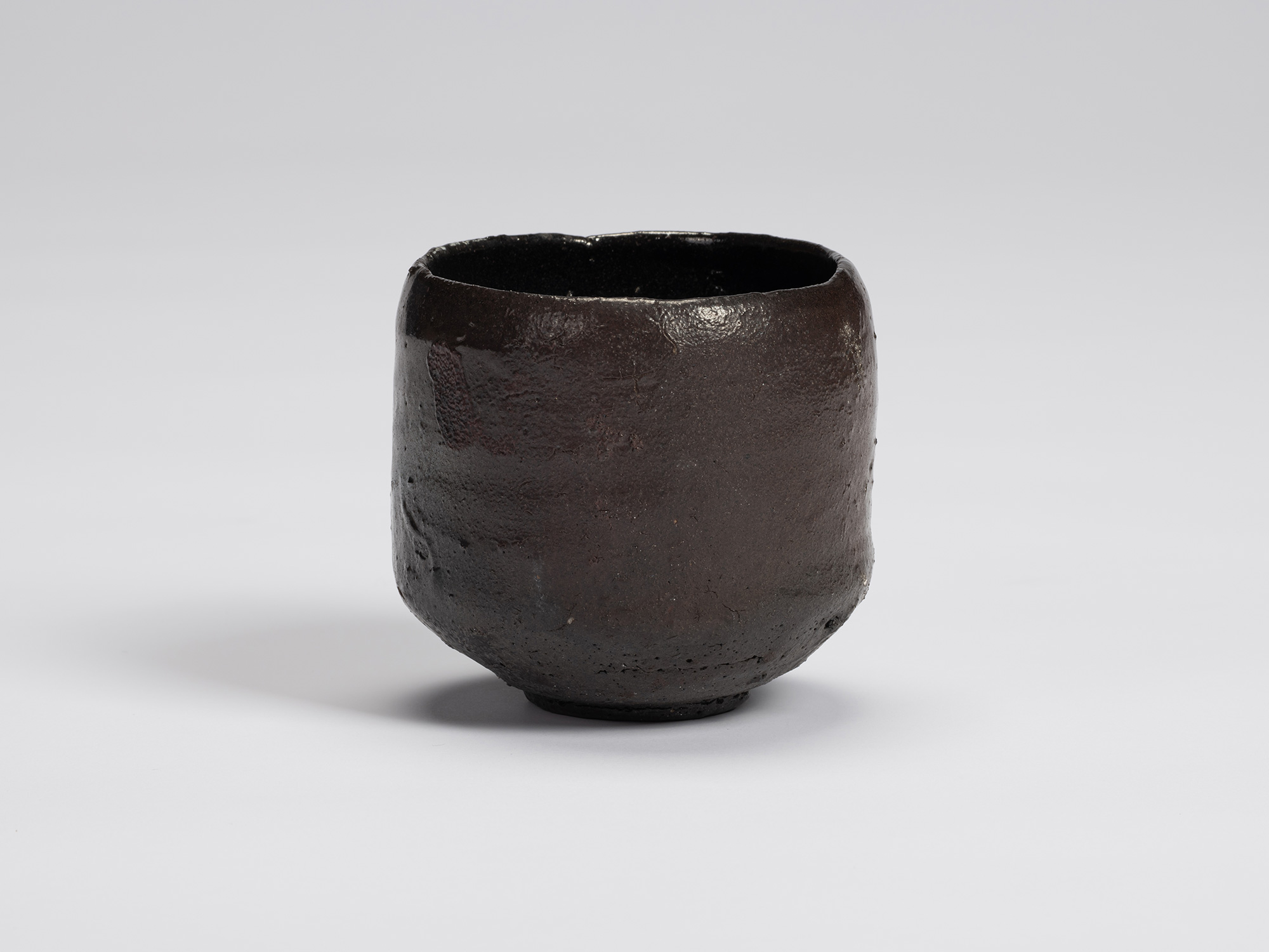 Front view of Shiro Tsujimura's Kuro Chawan, a hand-formed black tea bowl with a gently rounded...