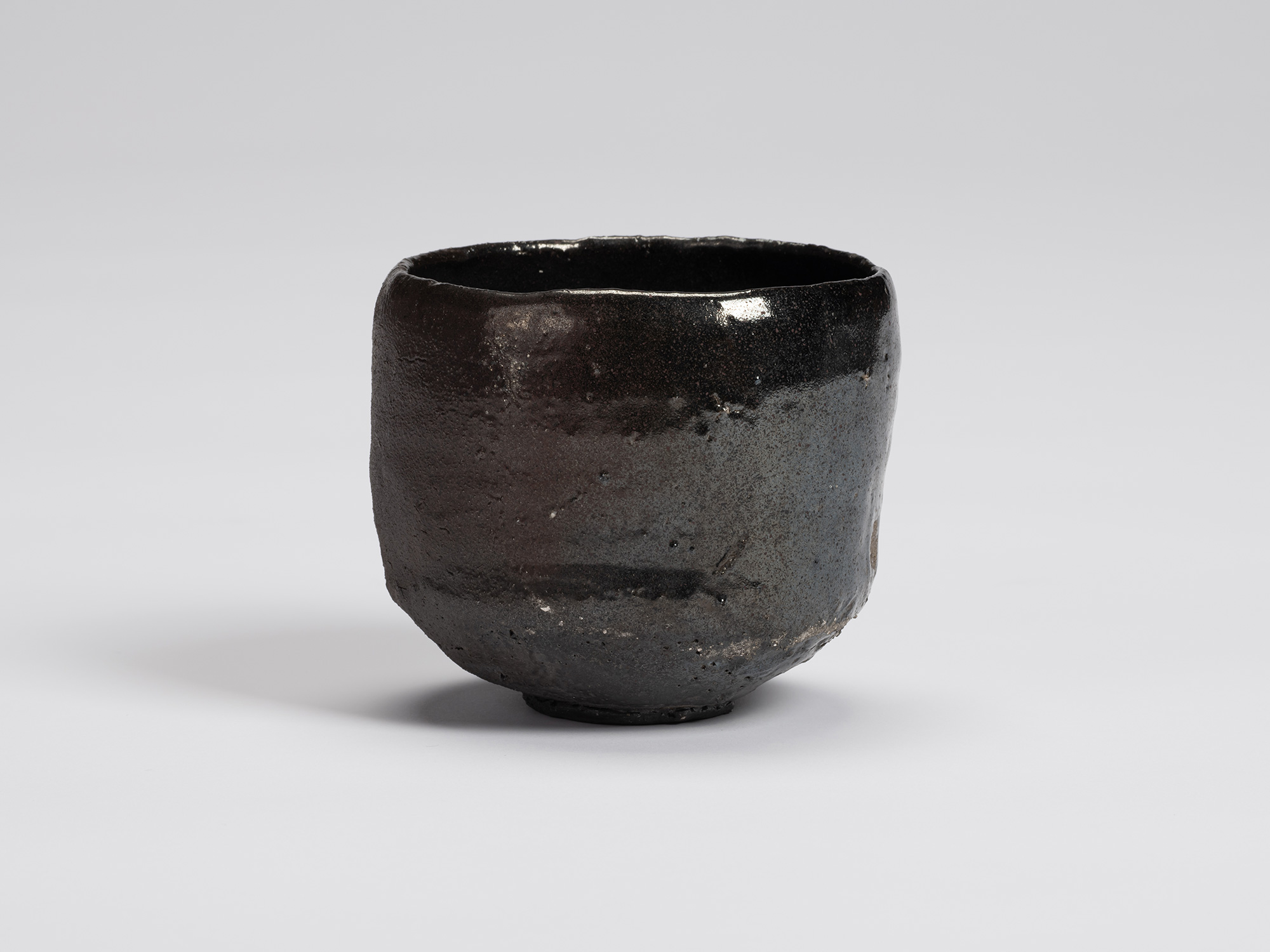 Front view of Shiro Tsujimura's Kuro Chawan, a hand-formed black tea bowl with a gently rounded...