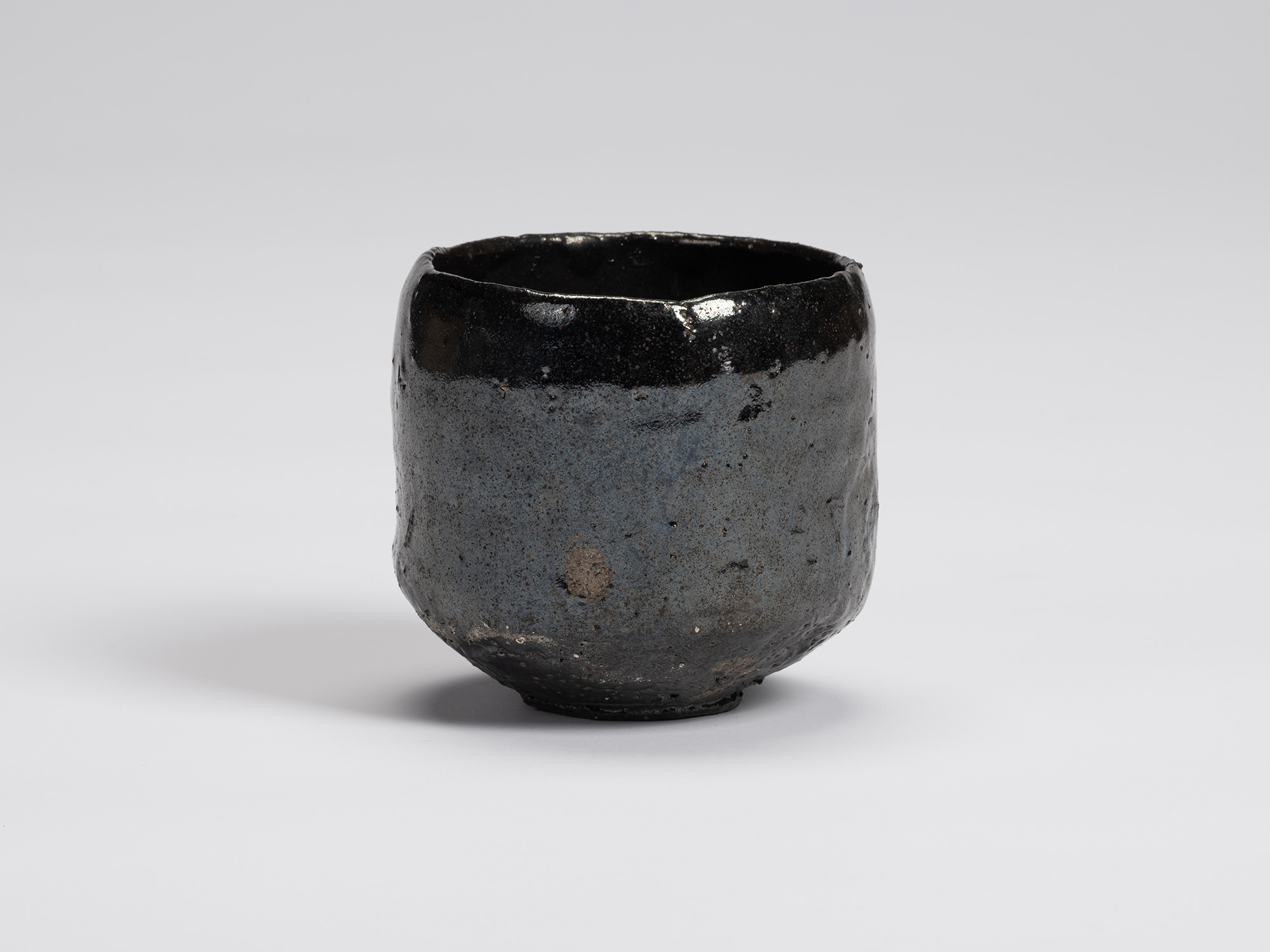 Front view of Shiro Tsujimura's Kuro Chawan, a hand-formed black tea bowl with a gently rounded...