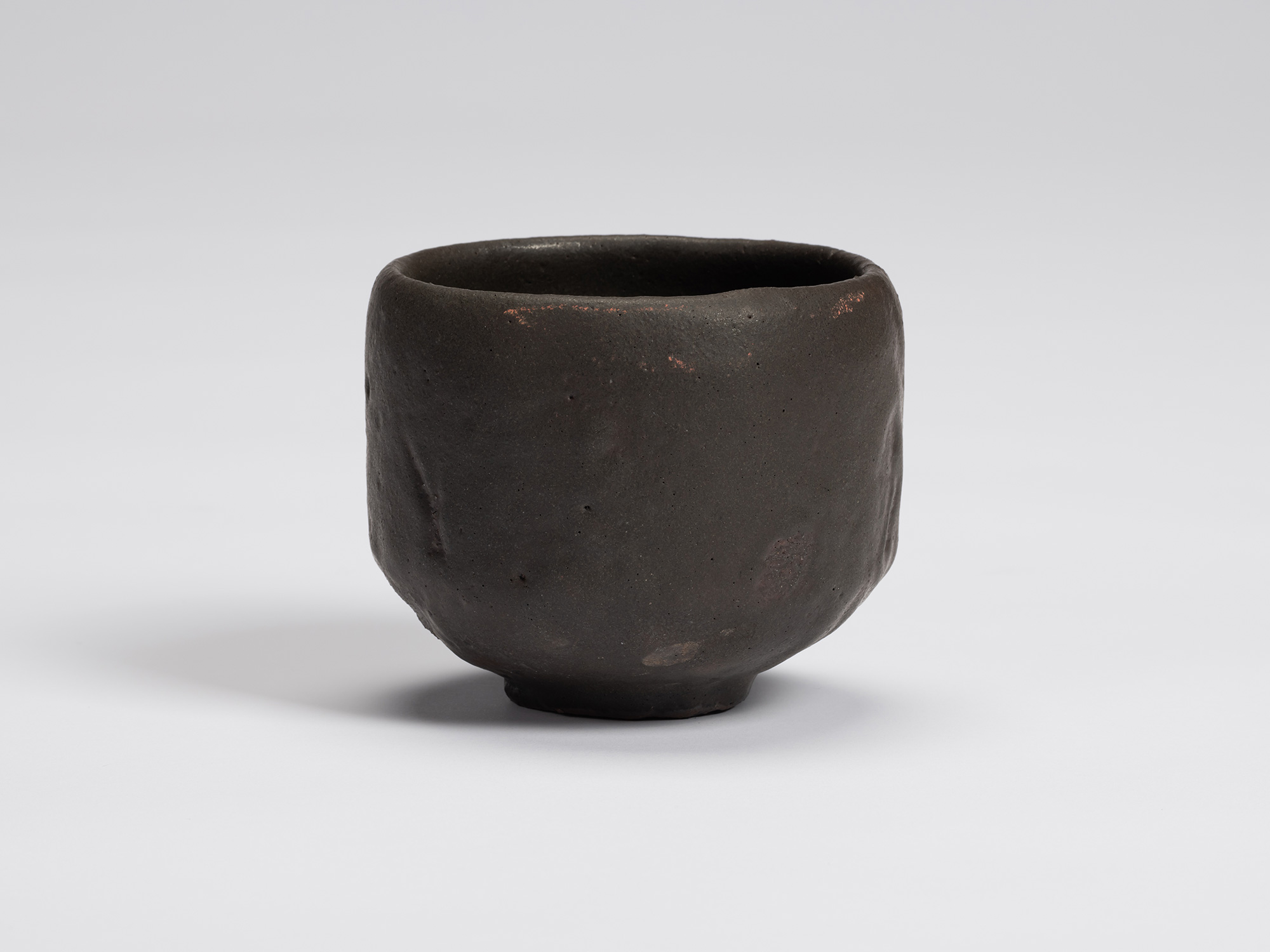 Front view of Kuro Chawan by Shiro Tsujimura, showing its gently rounded cylindrical form, matte...
