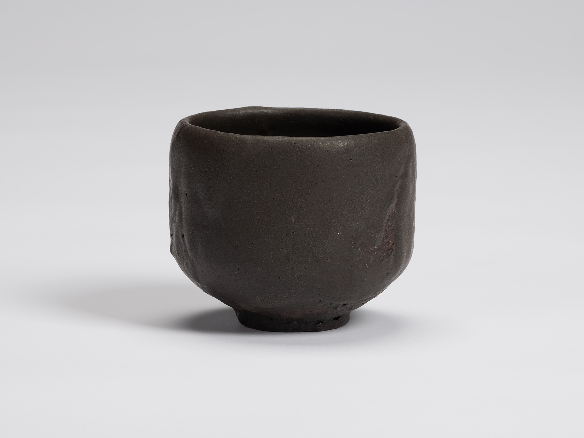 Front view of Kuro Chawan by Shiro Tsujimura, showing its gently rounded cylindrical form, matte...