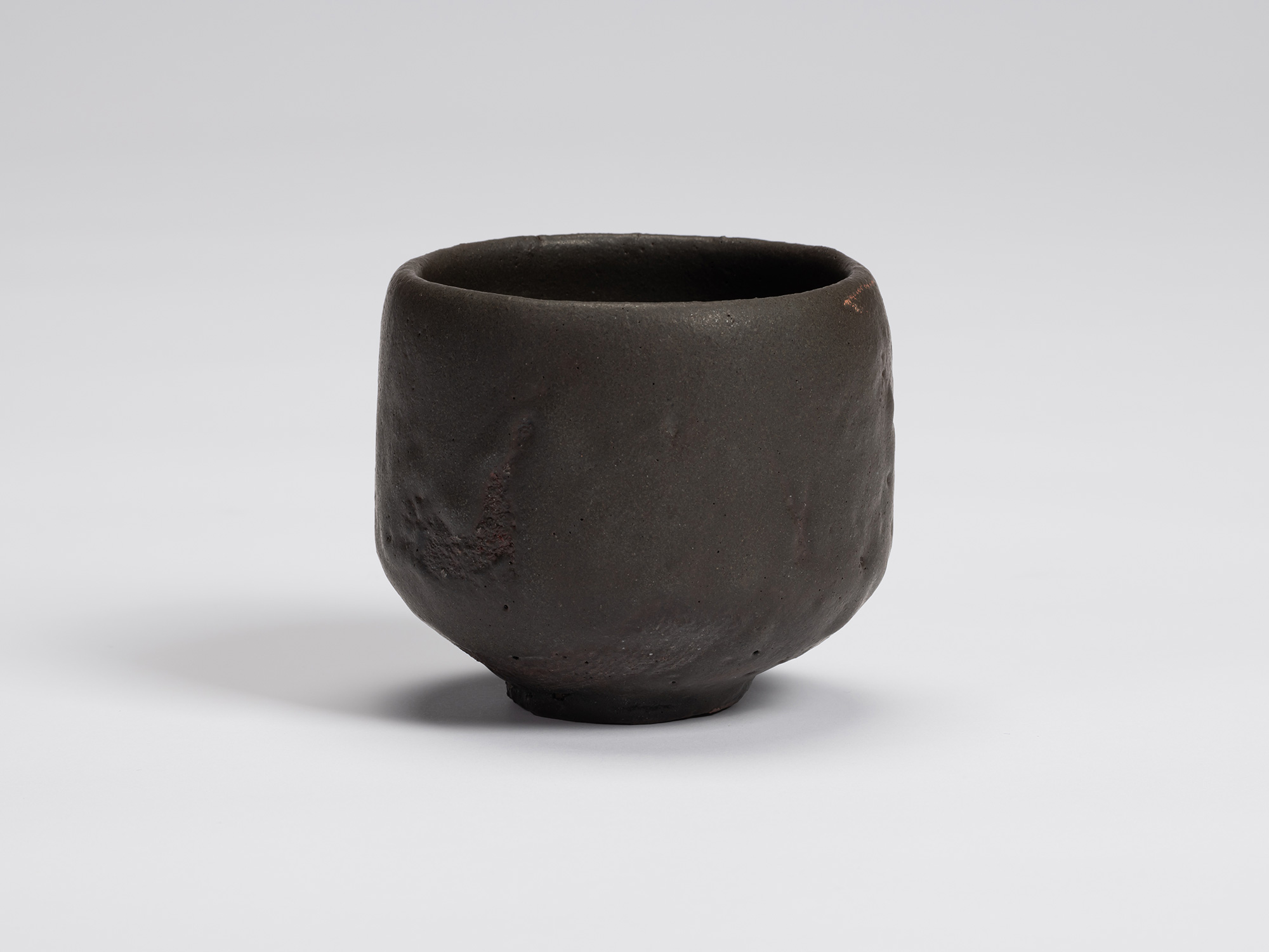 Front view of Kuro Chawan by Shiro Tsujimura, showing its gently rounded cylindrical form, matte...