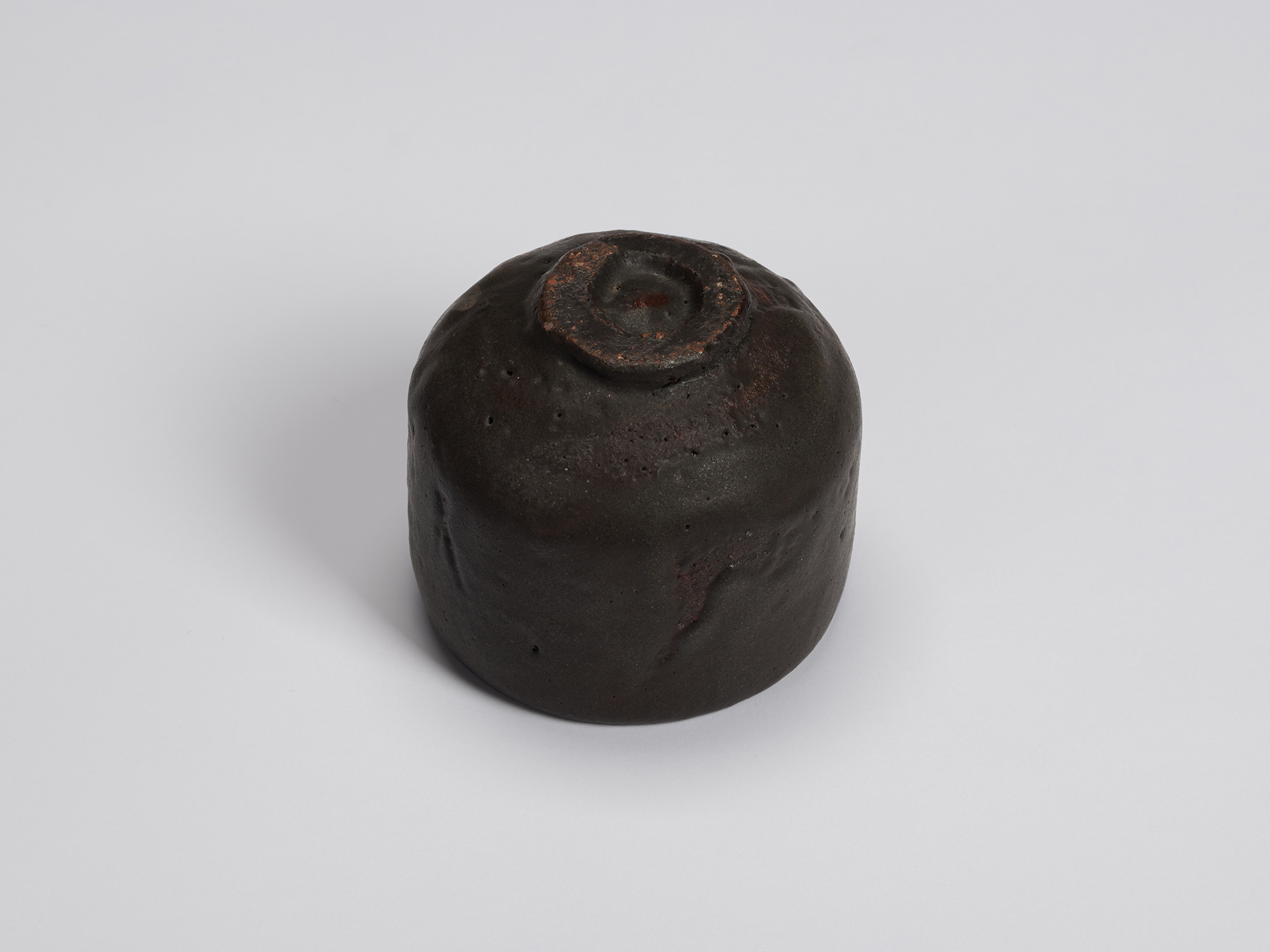 Bottom view of Kuro Chawan by Shiro Tsujimura, revealing its neatly trimmed circular foot ring,...