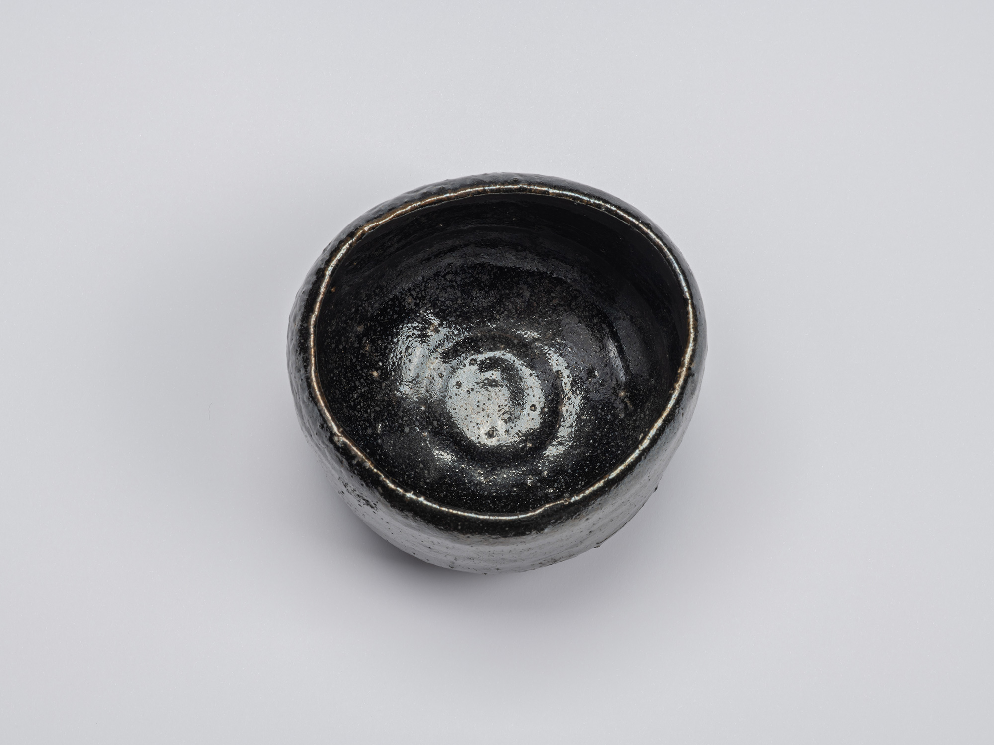 Overhead view of Kuro Chawan by Shiro Tsujimura, highlighting the softly irregular rim, deep bowl...