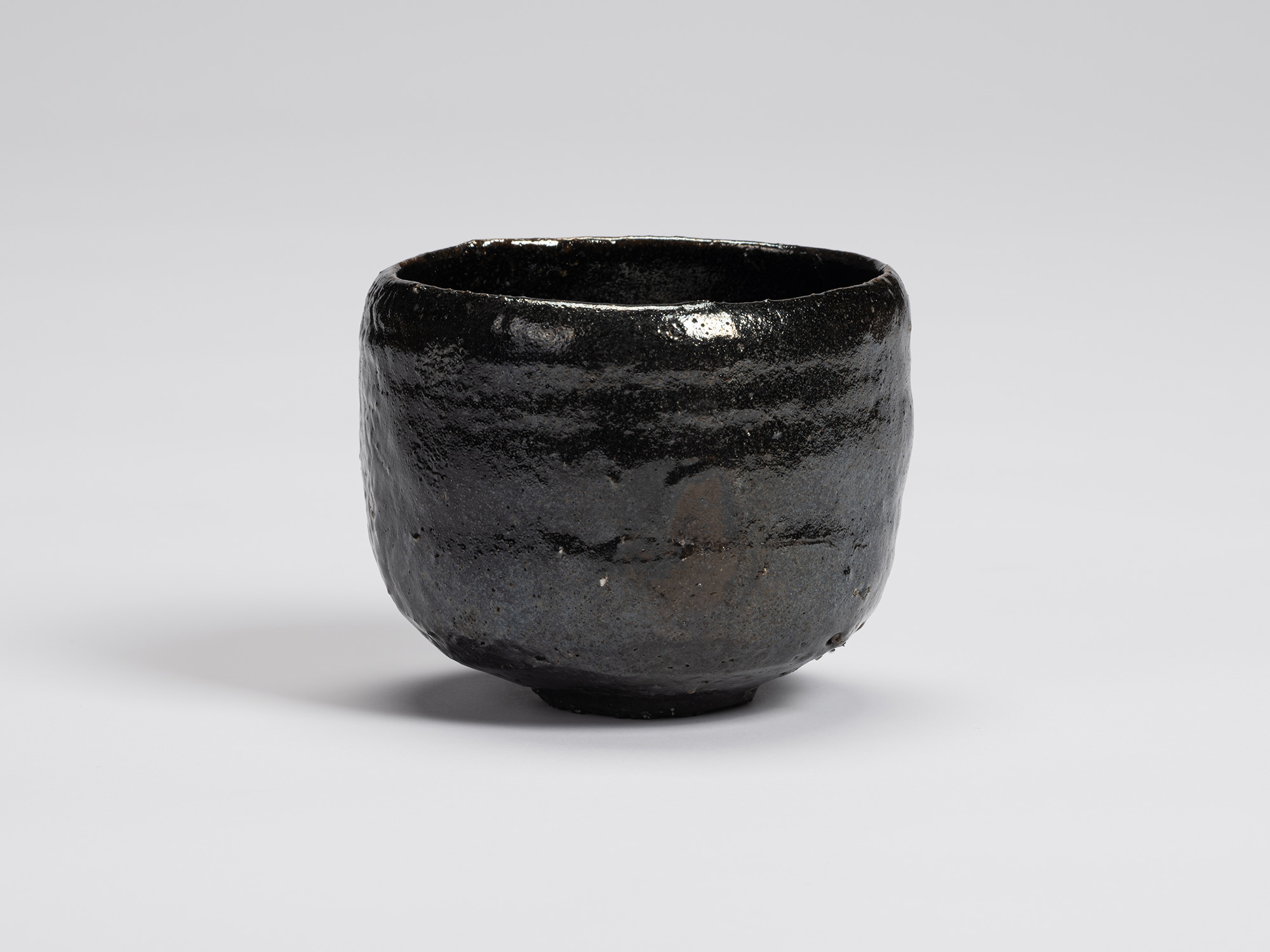 Front view of Kuro Chawan by Shiro Tsujimura, showing its gently rounded cylindrical form, lustrous...