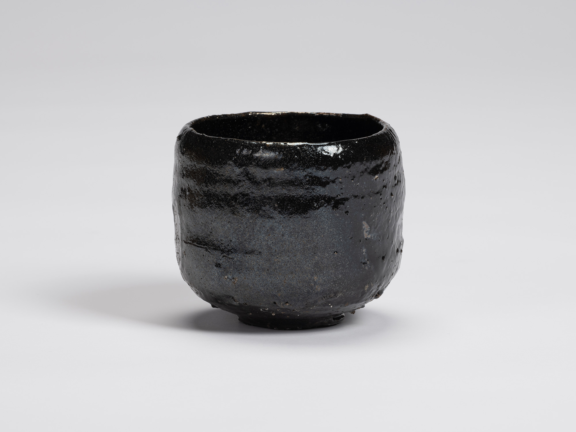 Front view of Kuro Chawan by Shiro Tsujimura, showing its gently rounded cylindrical form, lustrous...