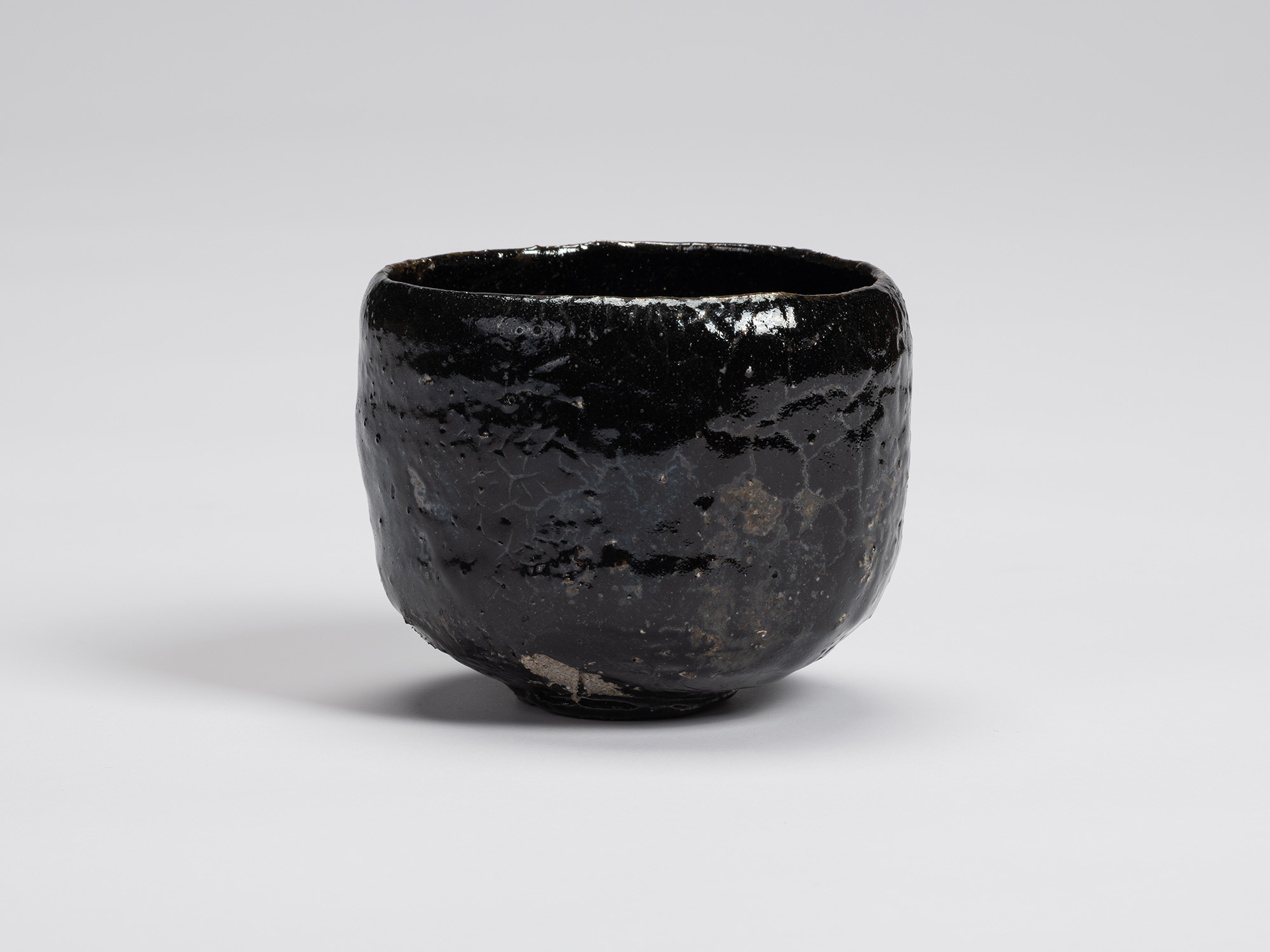Front view of Kuro Chawan by Shiro Tsujimura, showing its gently rounded cylindrical form, lustrous...