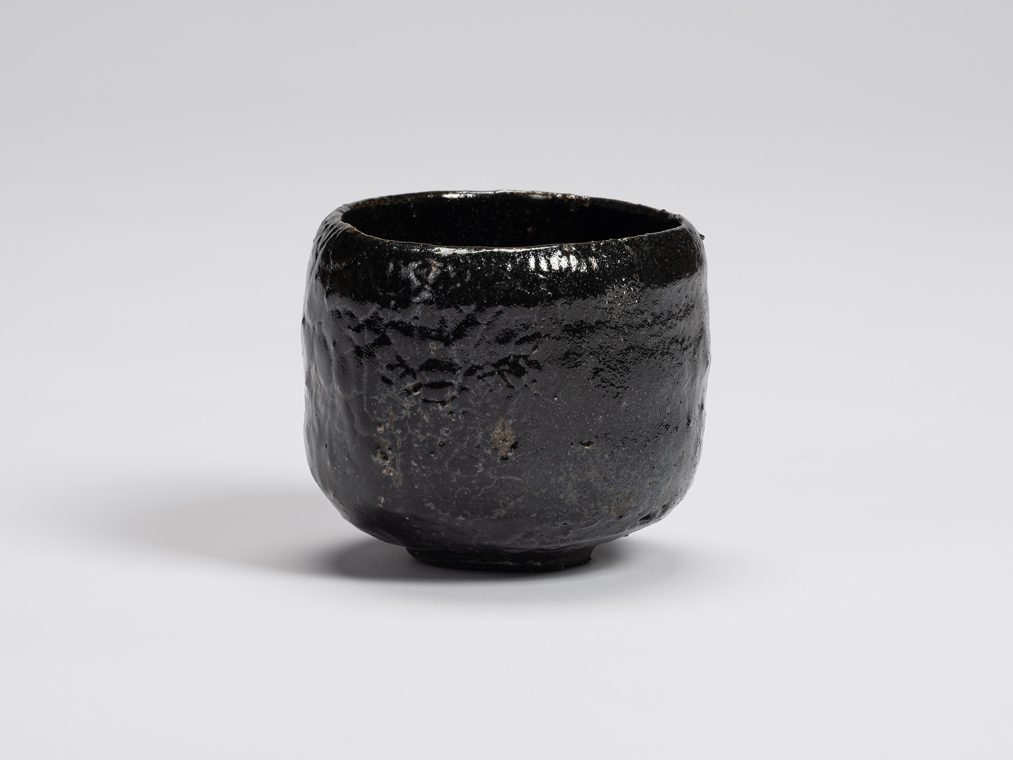 Front view of Kuro Chawan by Shiro Tsujimura, showing its gently rounded cylindrical form, lustrous...