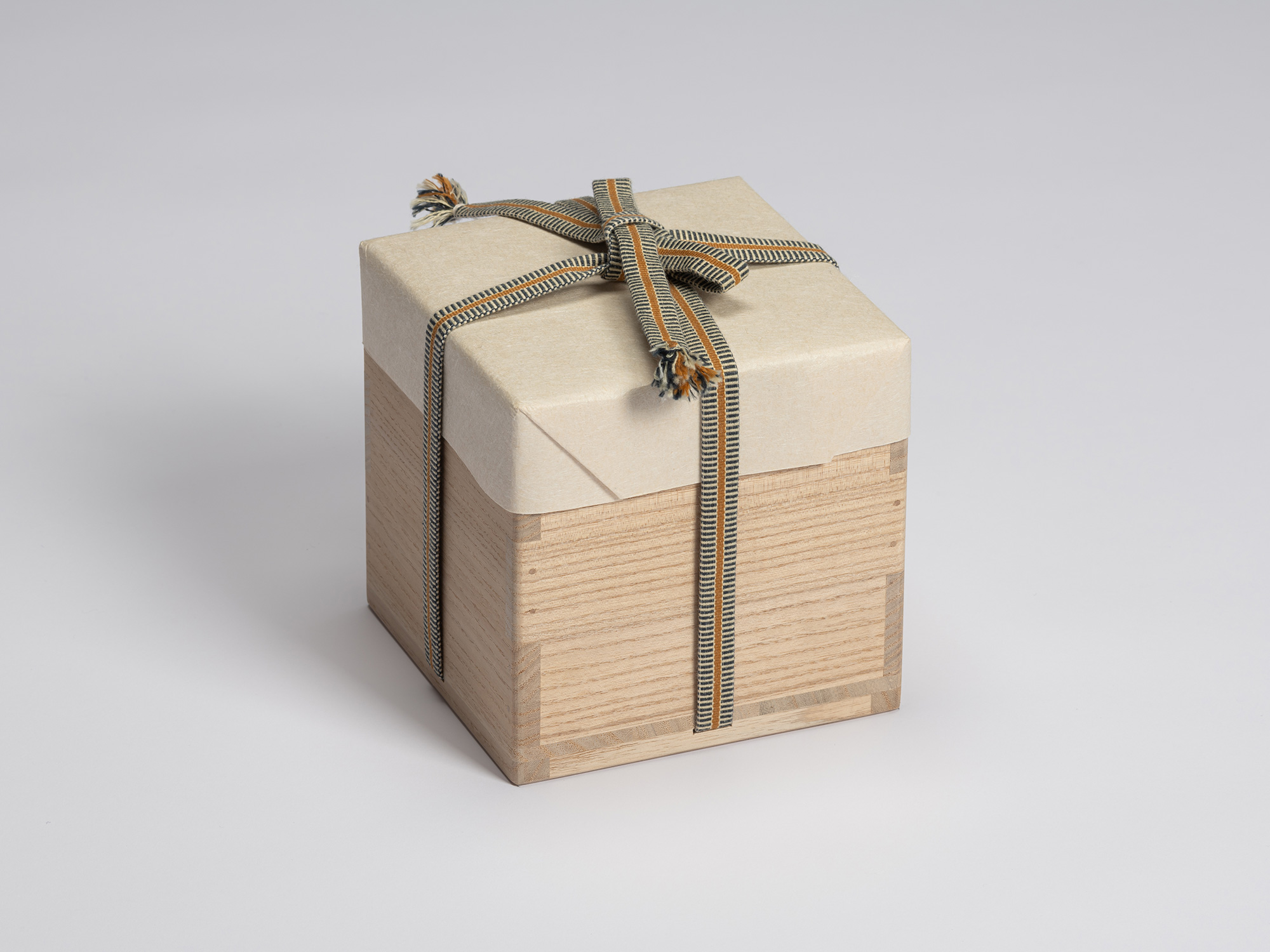 Paulownia wood presentation box for Shiro Tsujimura's Kuro Chawan, wrapped in protective white...
