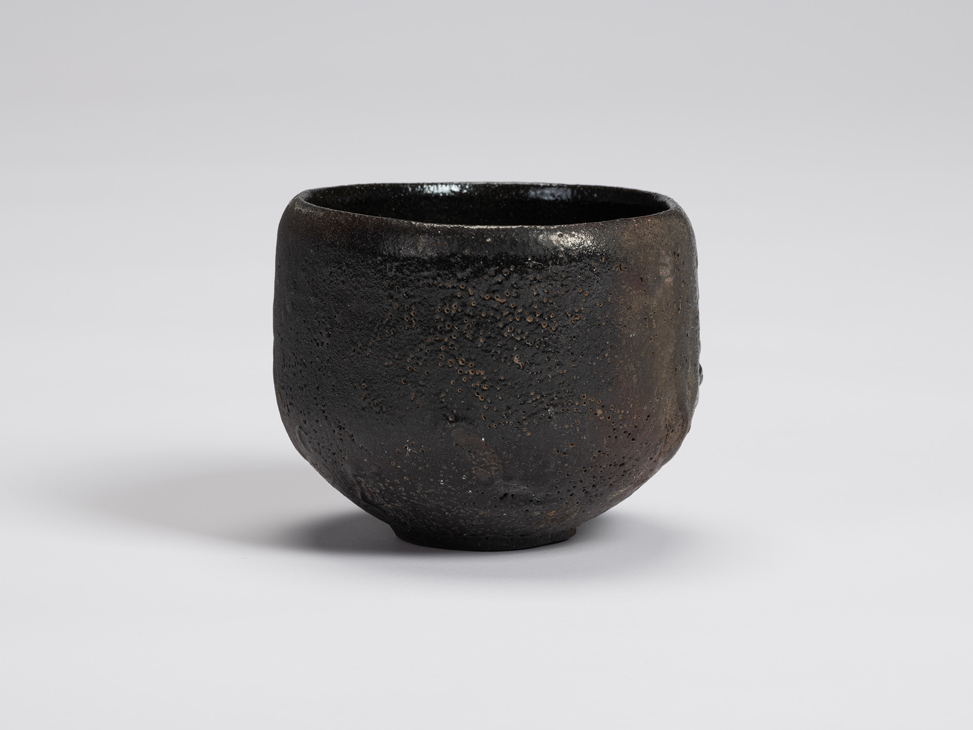 FFront view of Shiro Tsujimura's Kuro Chawan featuring a rounded, slightly tapering form with a...