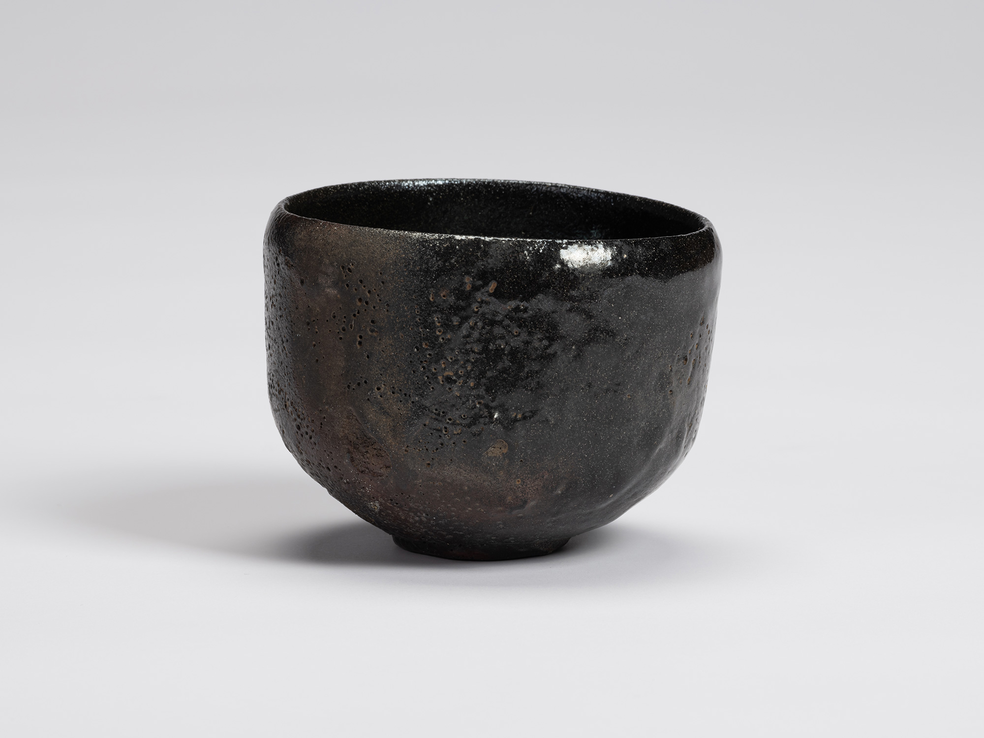 Front view of Shiro Tsujimura's Kuro Chawan featuring a rounded, slightly tapering form with a...