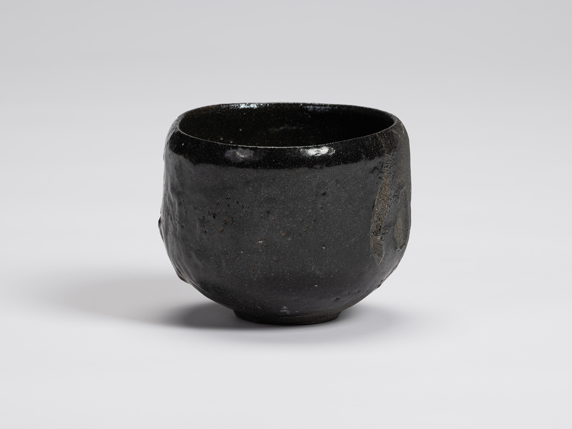Front view of Shiro Tsujimura's Kuro Chawan featuring a rounded, slightly tapering form with a...
