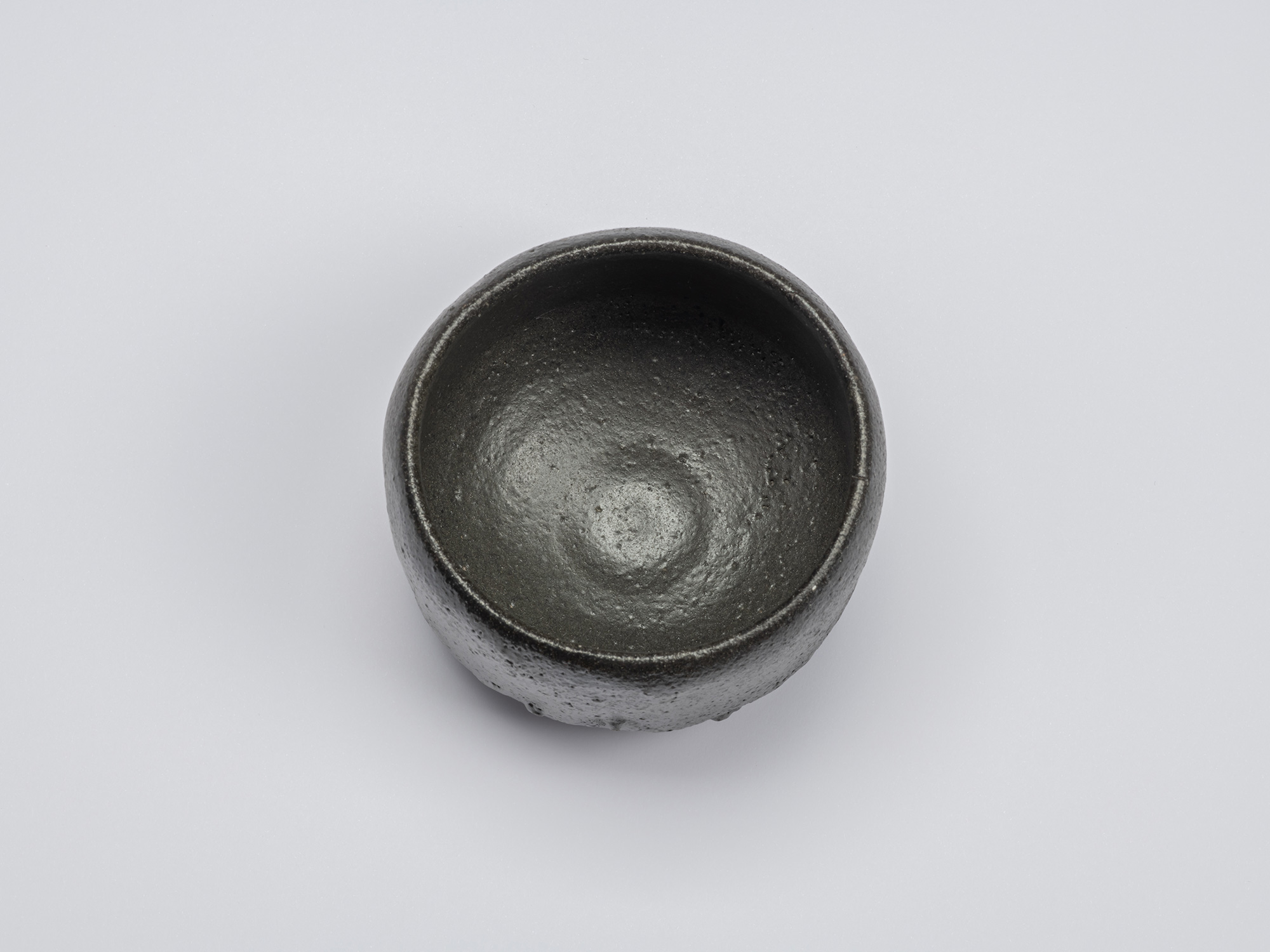 Overhead view of Chawan No. 7 revealing its deep, rounded interior with a softly burnished black...