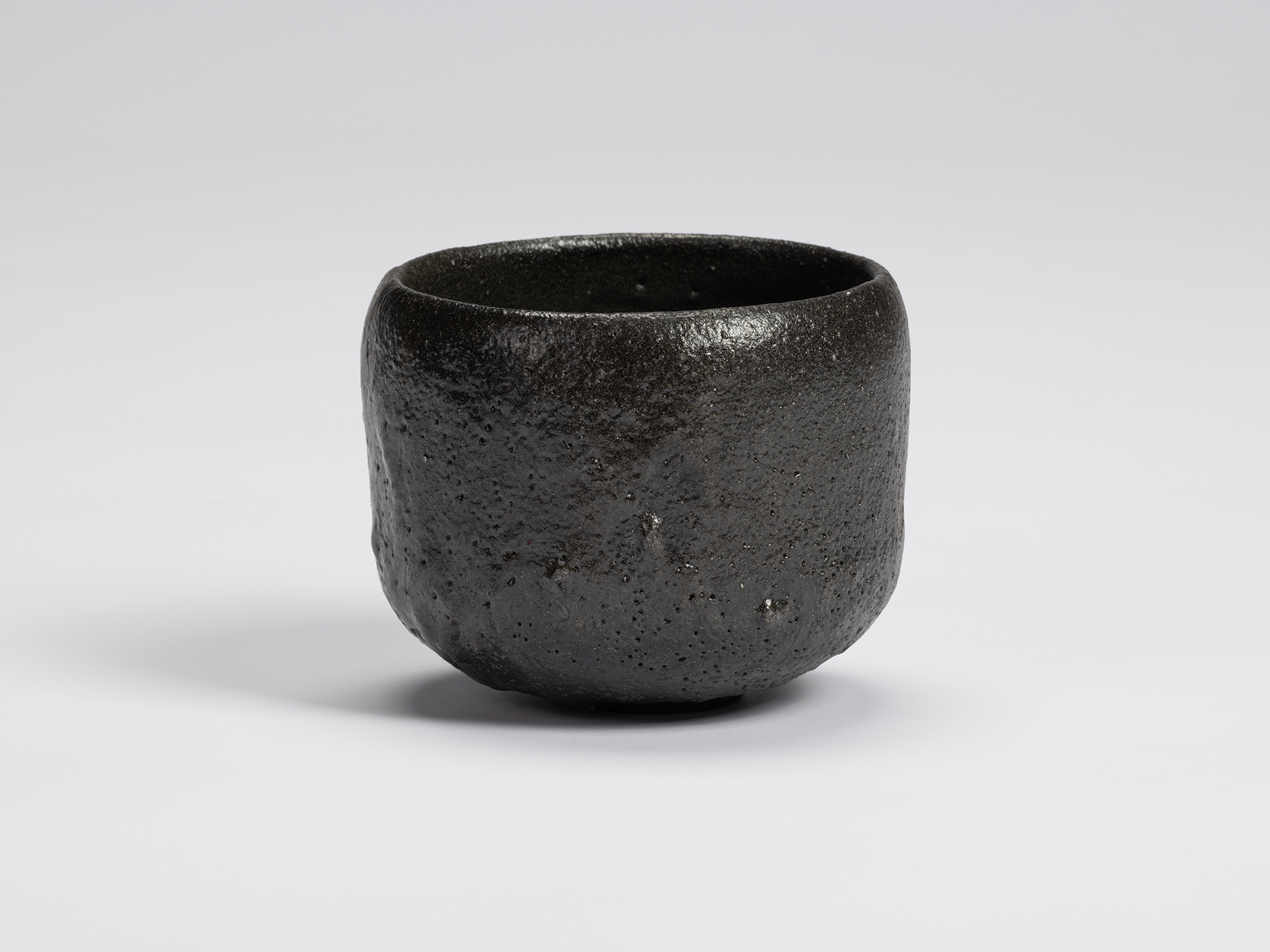 Front view of Chawan No. 7 by Shiro Tsujimura, a hand-formed black tea bowl with a rounded cylindrical...