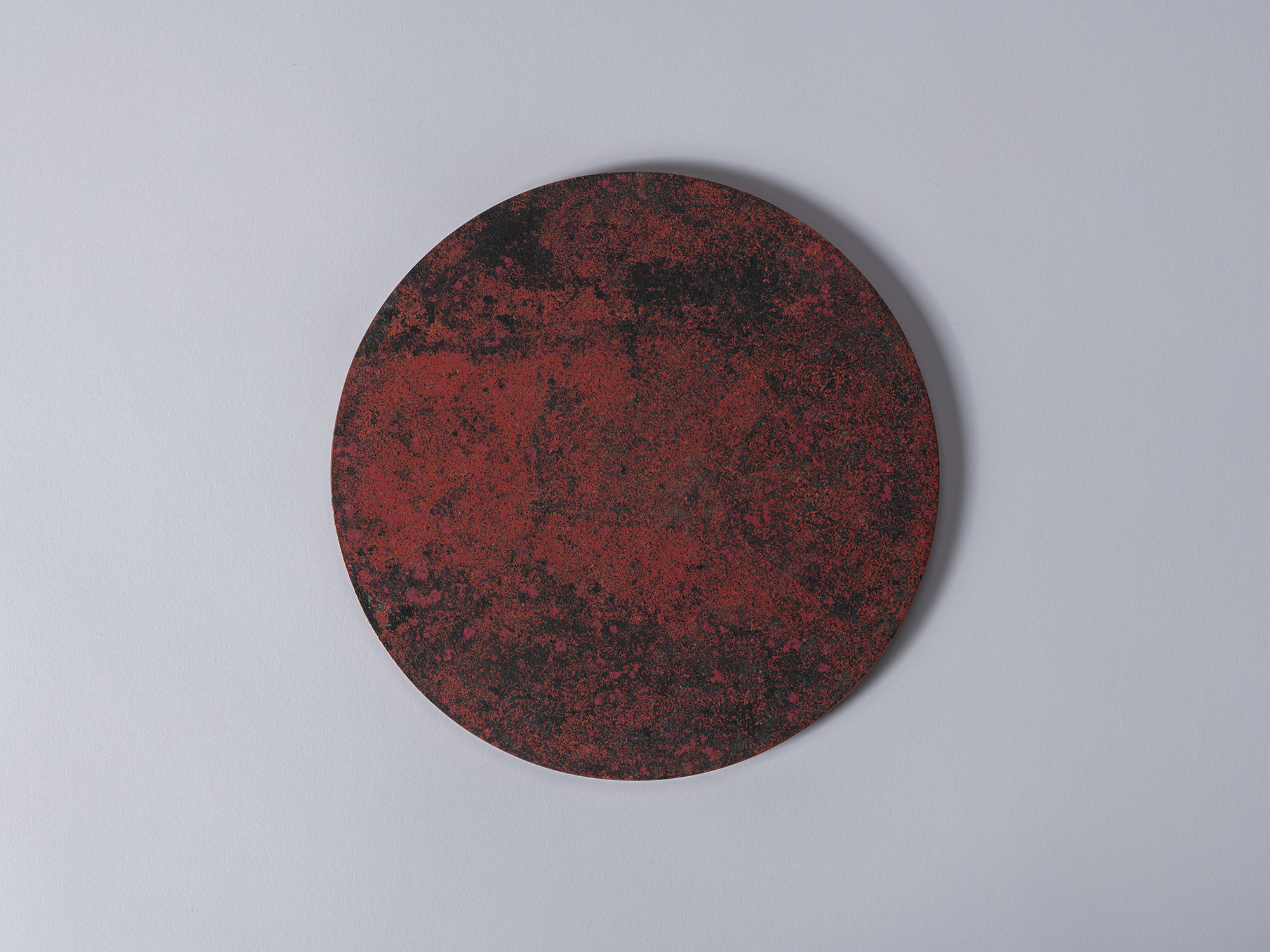 Overhead view of the removable circular lid from Cylinder with Lid – Red by Koji Hatakeyama. The...