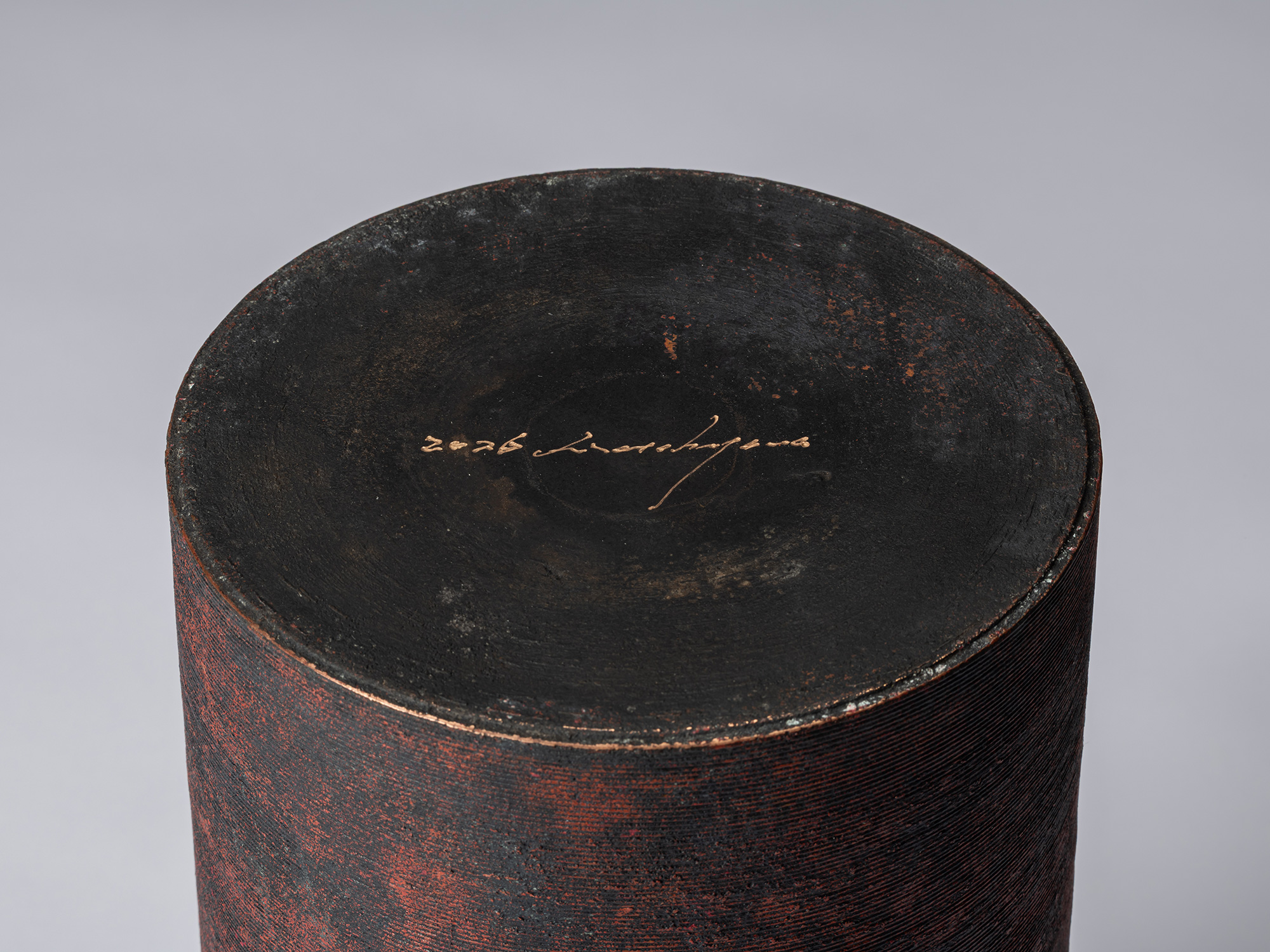 Bottom view of Cylinder with Lid – Red by Koji Hatakeyama showing the recessed base with the artist's...