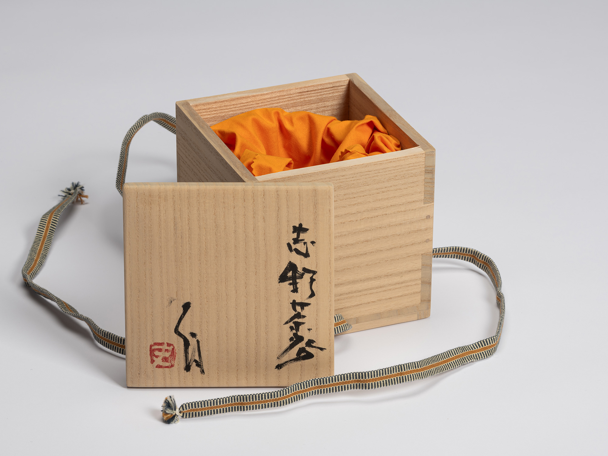 Tomobako for a Shino Chawan by Shiro Tsujimura shown with the lid removed and placed in front of...
